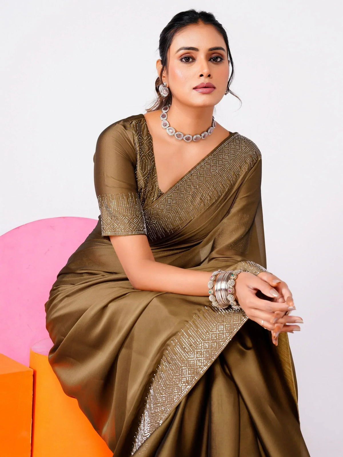 Olive green designer saree with sequin work, paired with statement jewelry for ethnic occasions