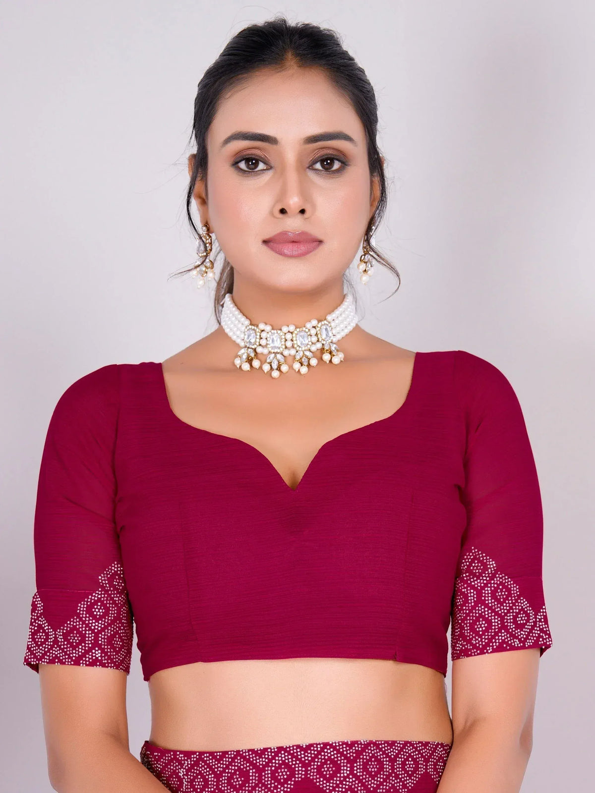Maroon ethnic blouse with pearl embroidery, paired with matching skirt and pearl jewelry for Indian wear