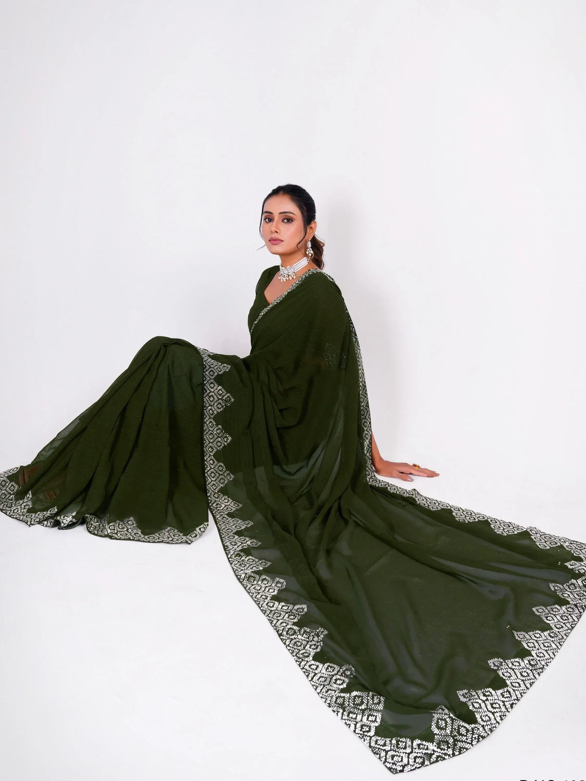 Olive green ethnic saree with white geometric border, styled with pearl jewelry for Indian occasions