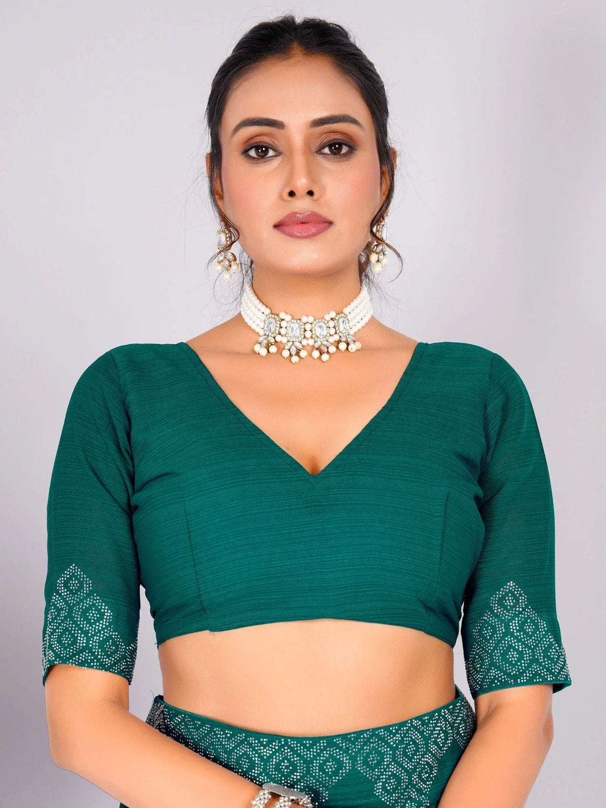 Emerald green designer lehenga choli with embellished sleeves and pearl jewelry