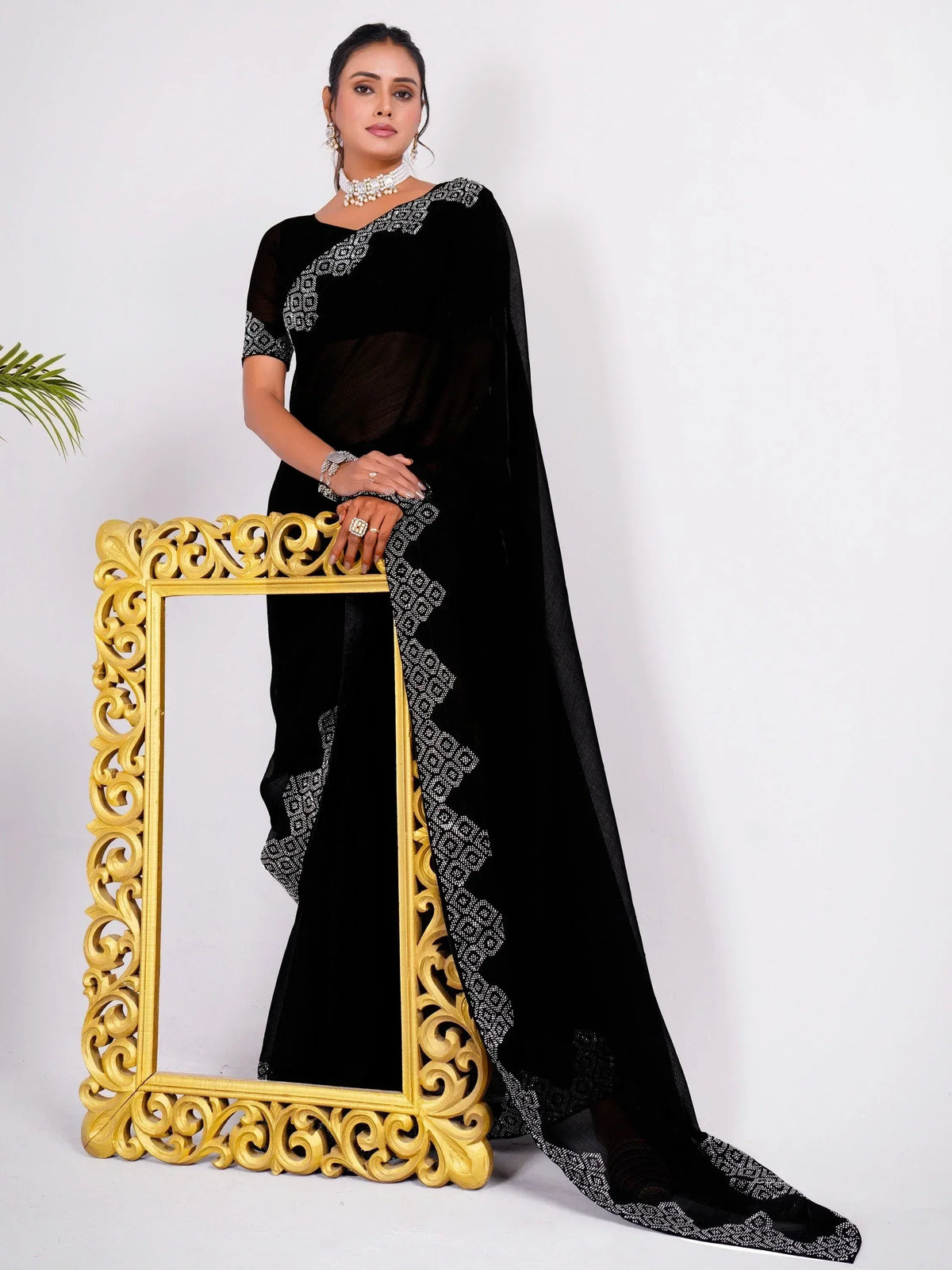 Black velvet saree with white embroidery, styled with pearl jewelry and gold frame, Indian ethnic wear