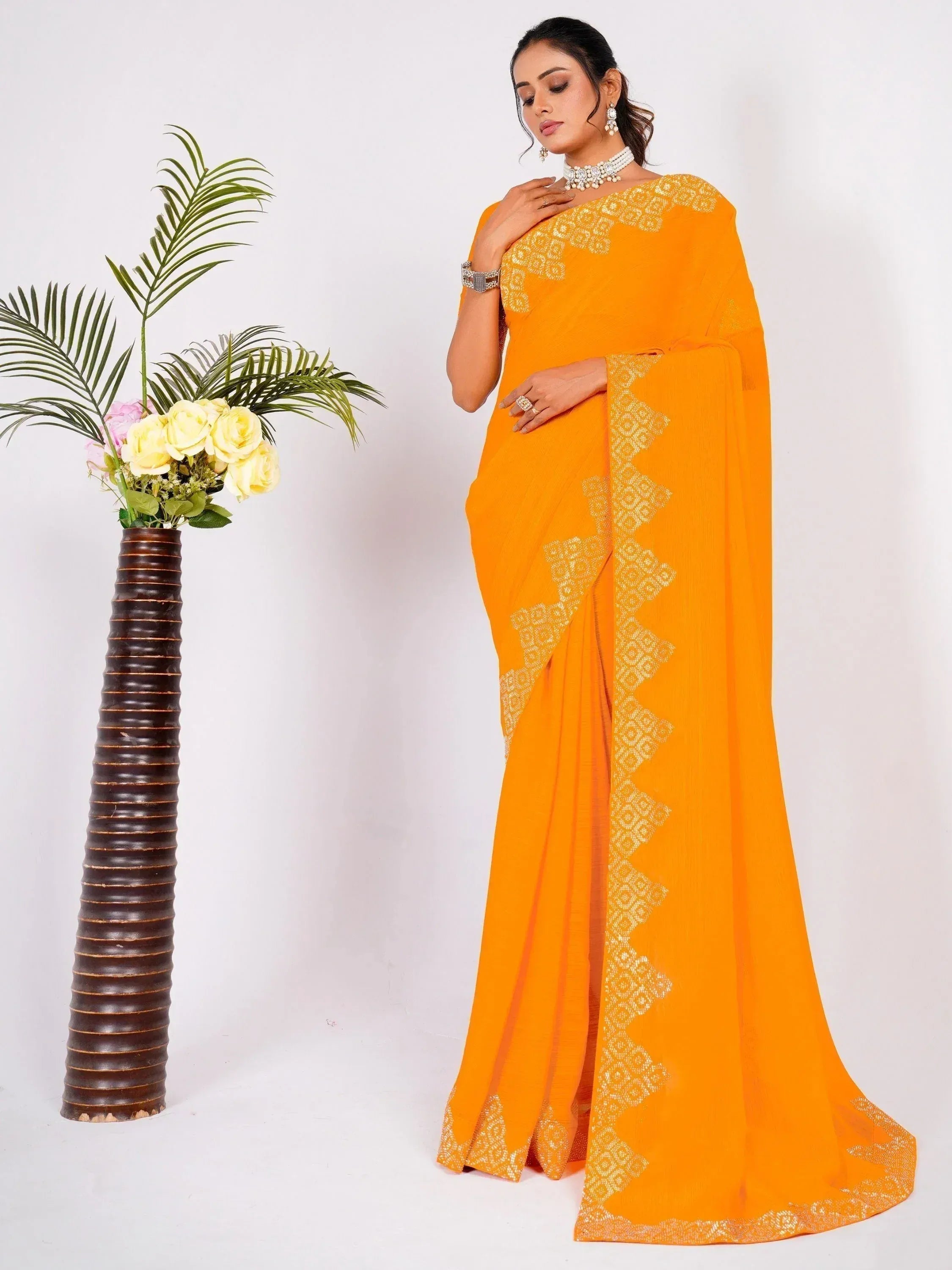 Vibrant orange saree with gold geometric embroidery, styled with traditional jewelry for ethnic wear.