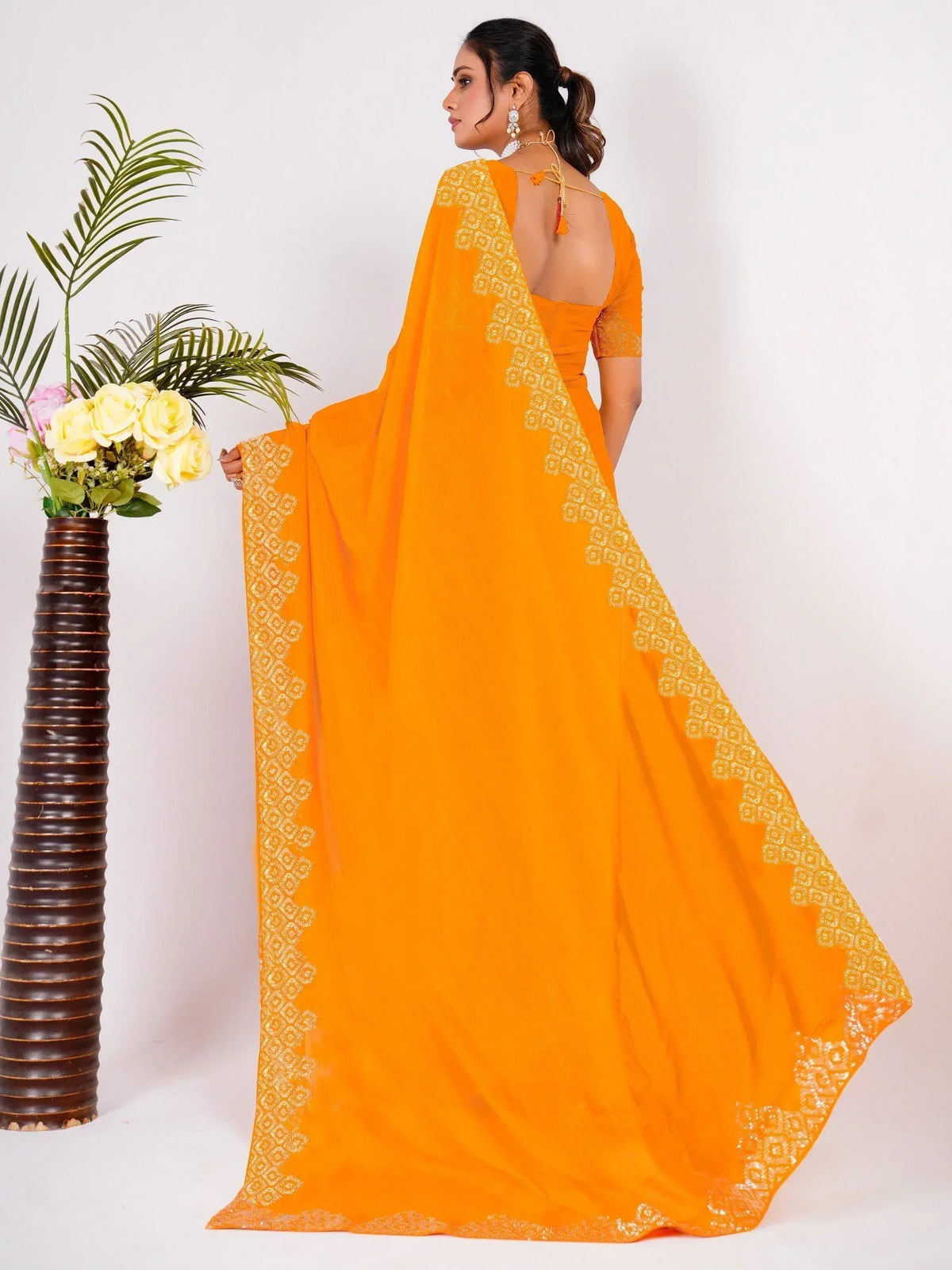 Vibrant orange saree with gold geometric border, backless blouse, perfect for ethnic occasions