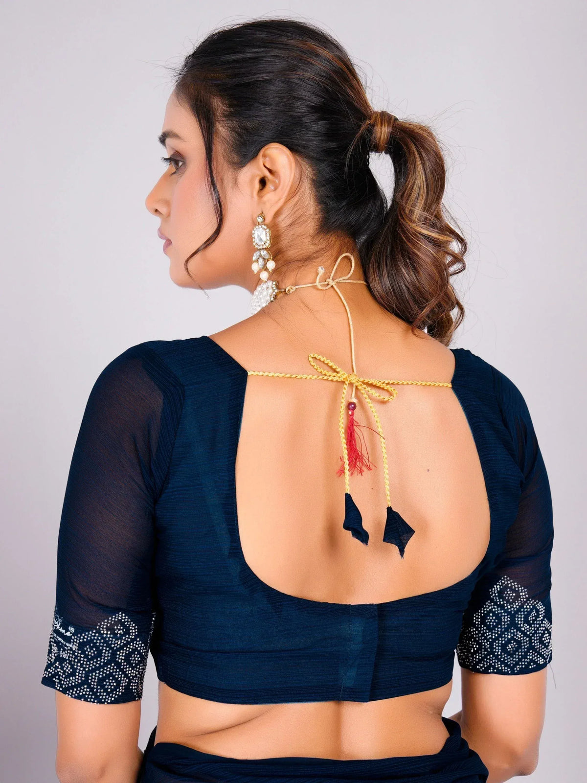 Navy blue saree blouse with open back, tie-up detail, and embellished sleeves for Indian ethnic wear