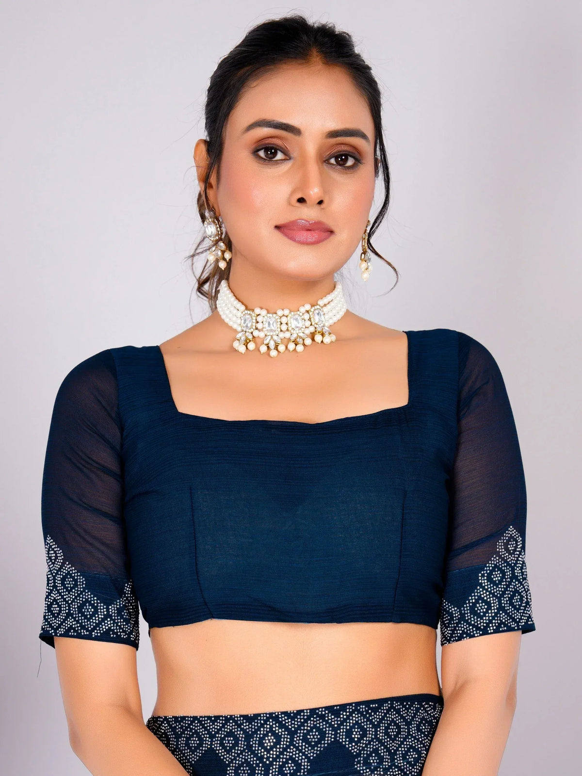 Navy blue ethnic crop top with sheer sleeves and embellished hem, paired with matching skirt and pearl jewelry