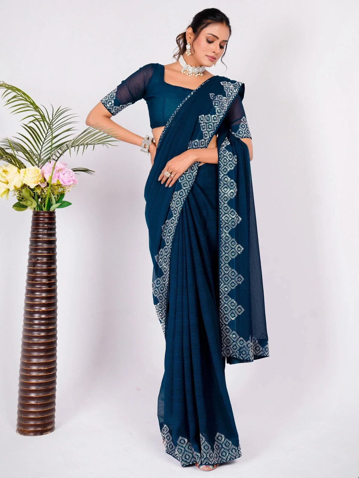 Teal blue saree with white geometric embroidery, sheer sleeves, and matching blouse for ethnic wear