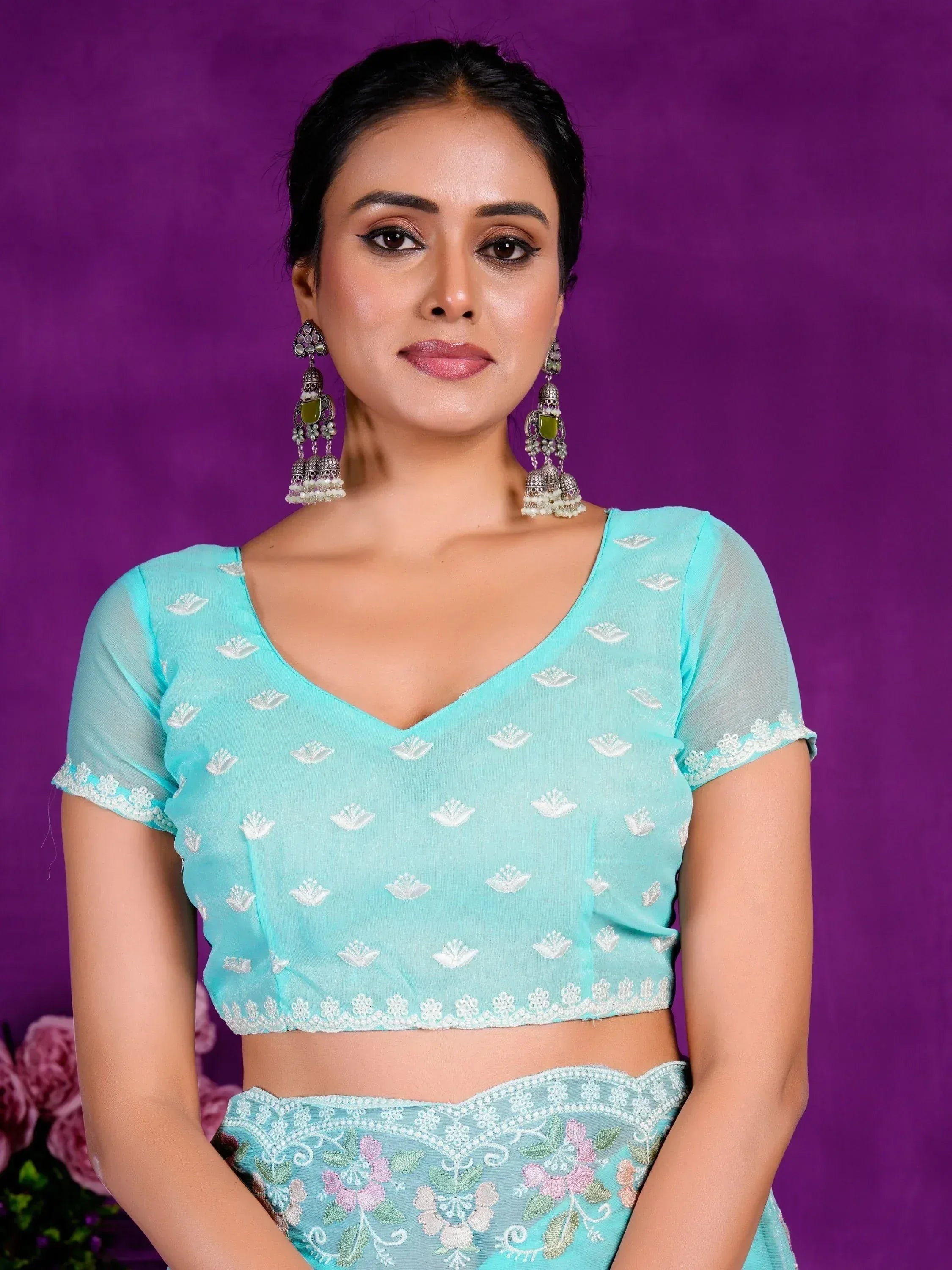 Mint green embroidered lehenga choli with floral motifs and jhumka earrings, perfect for Indian ethnic wear.