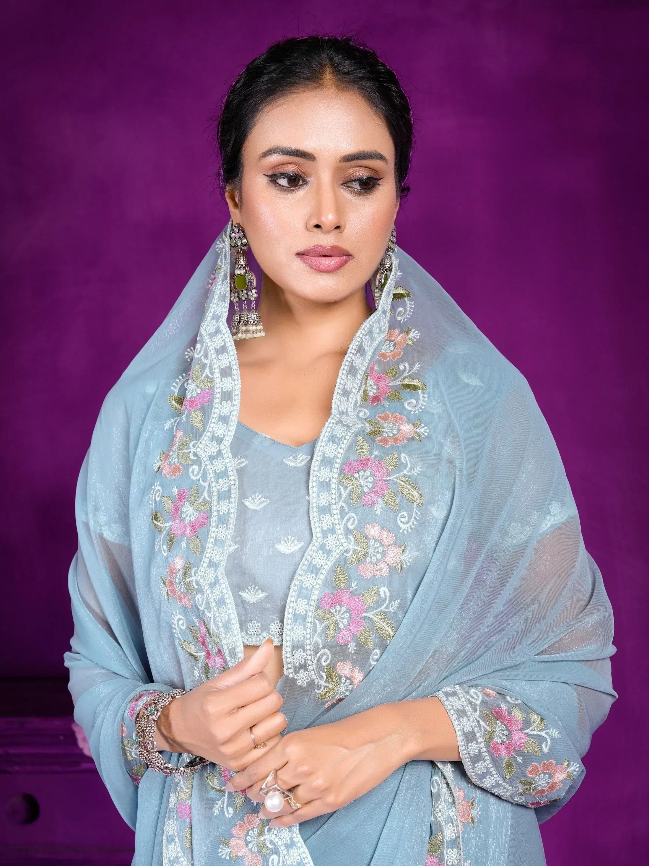 Woman in light blue embroidered salwar kameez with floral dupatta, traditional Indian ethnic wear