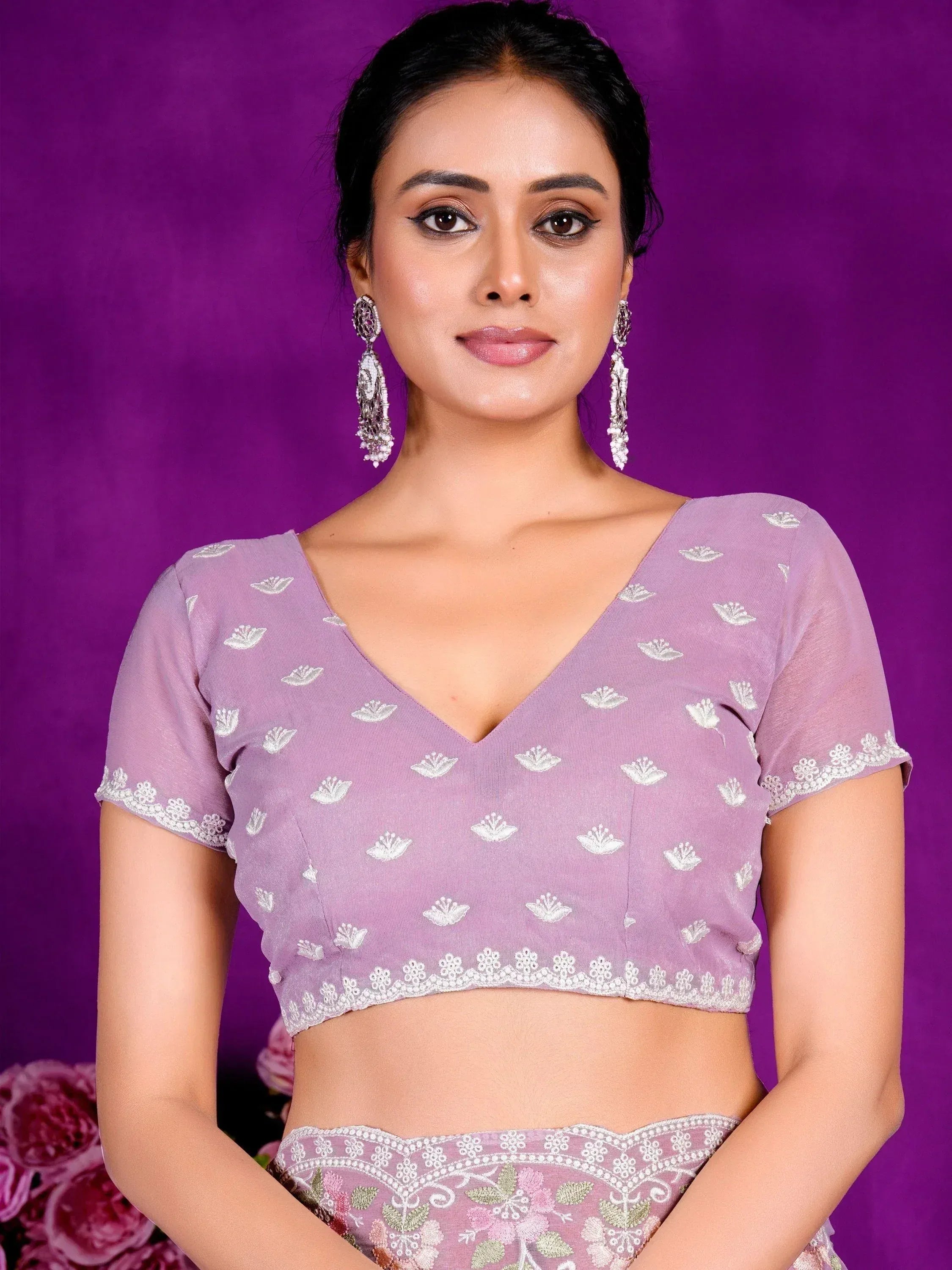 Lavender embroidered lehenga choli blouse with floral motifs and lace trim, paired with statement earrings