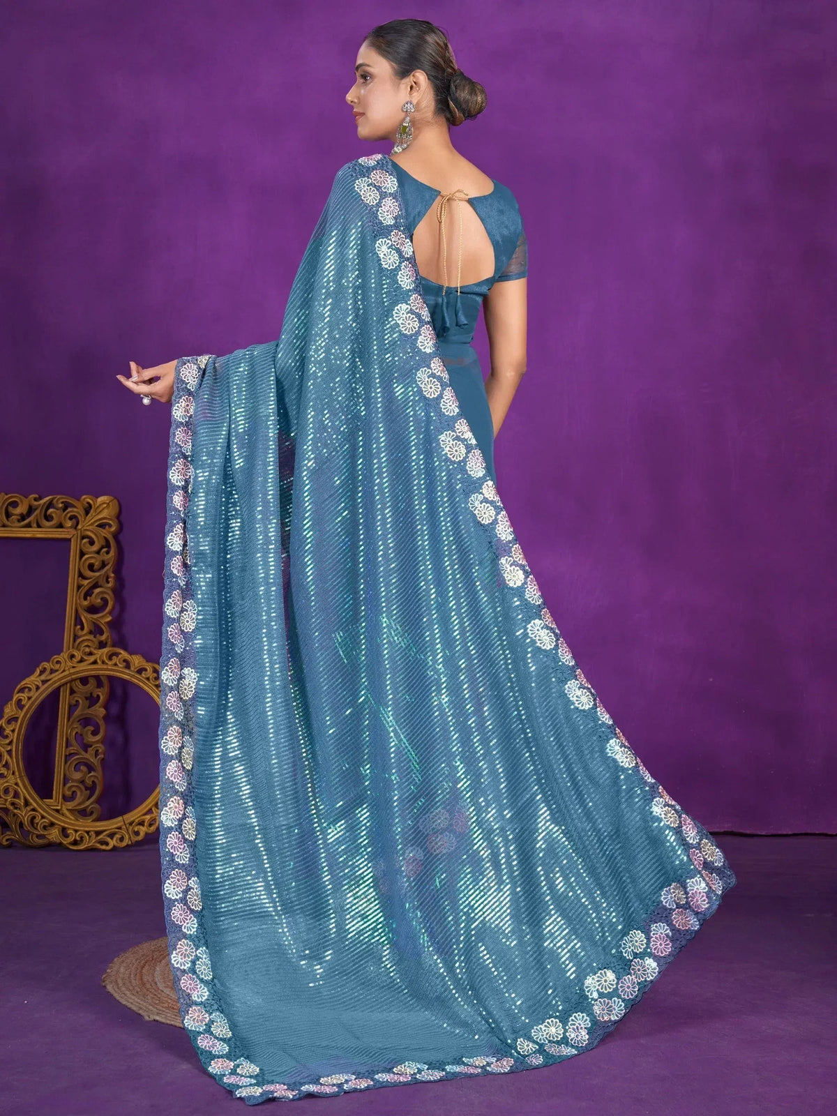 Teal designer saree with floral border and sequin detailing, perfect for ethnic occasions