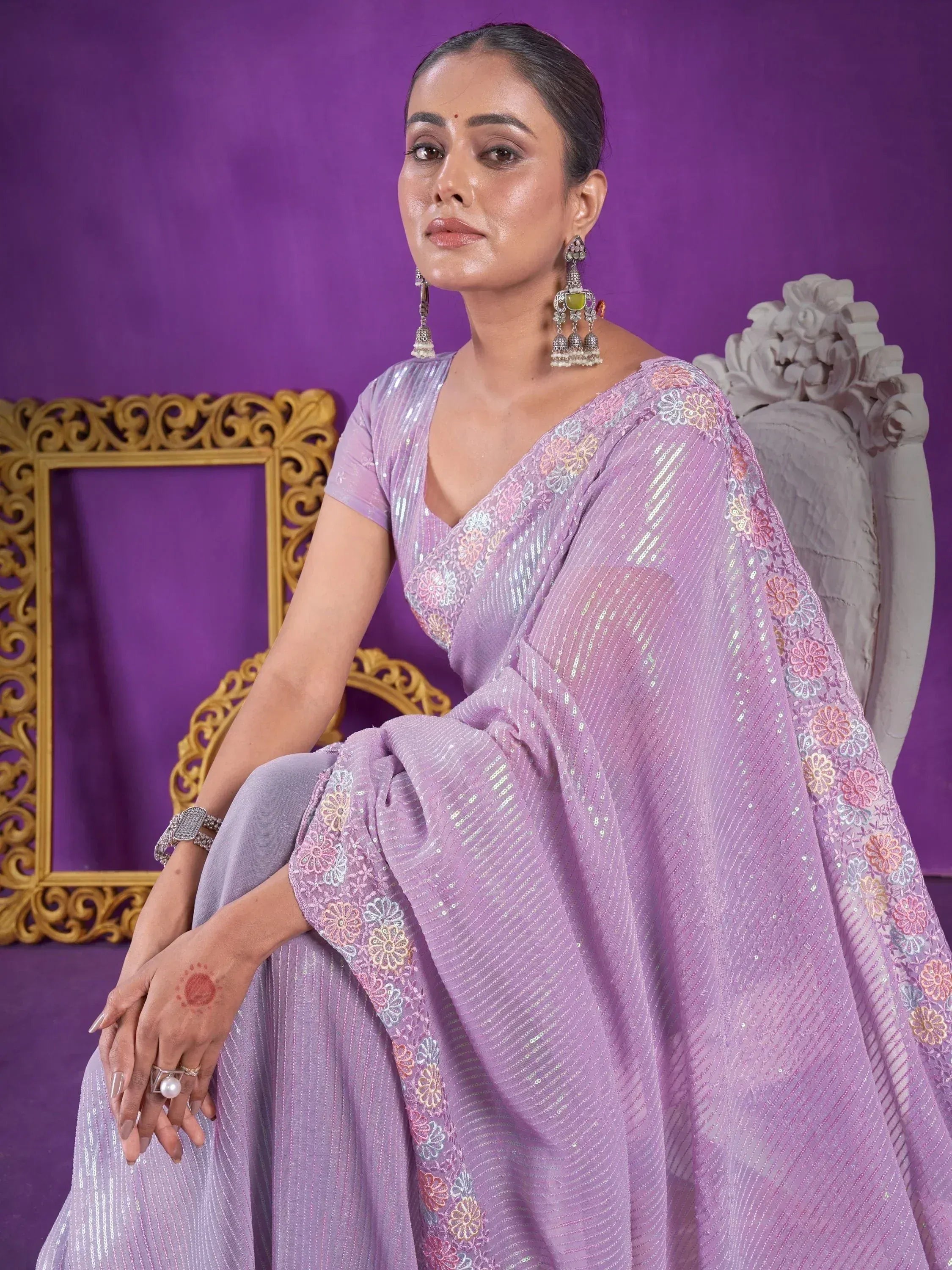 Lavender ethnic saree with floral embroidery and sequins, styled with jhumka earrings for festive occasions