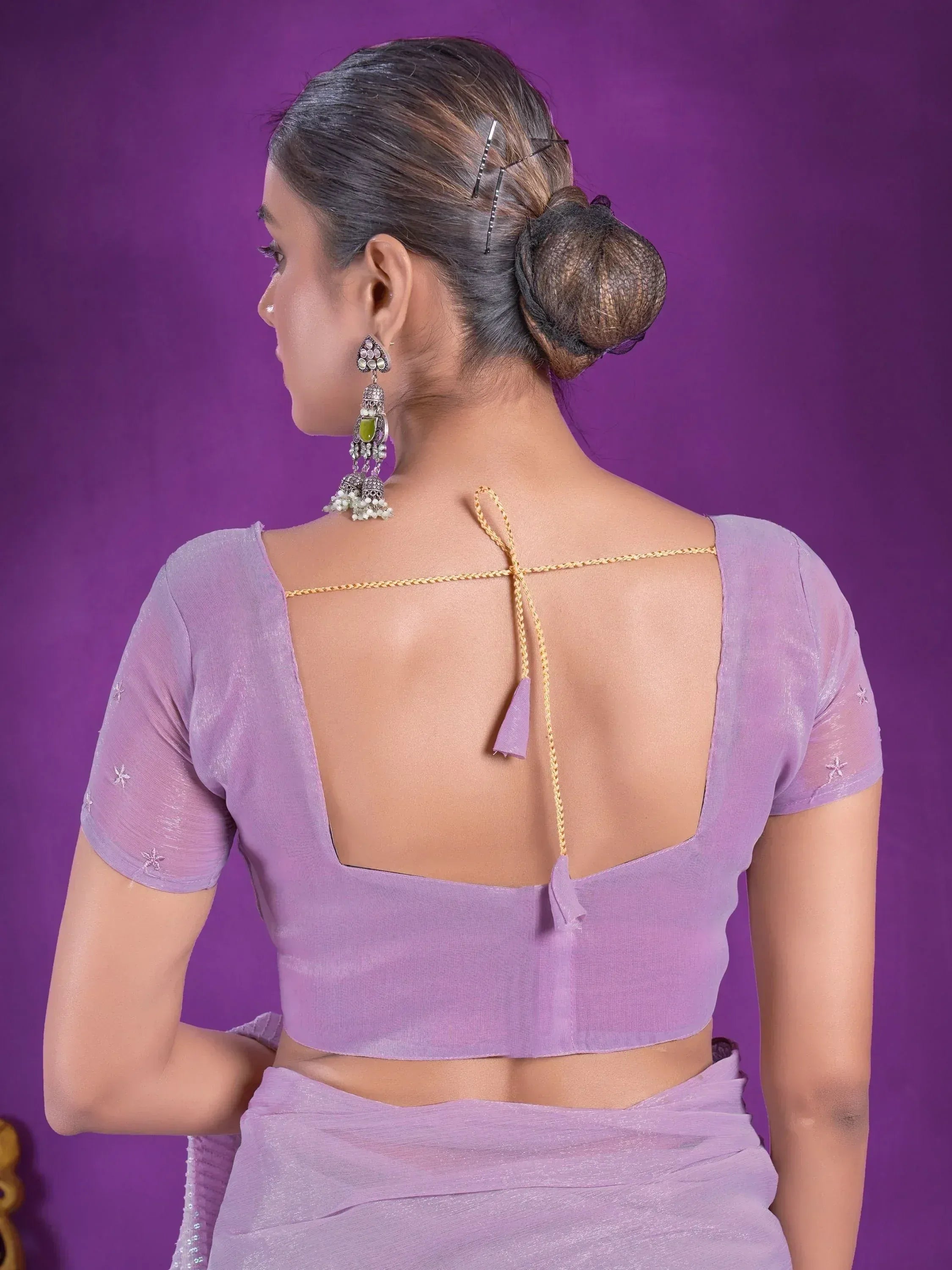 Lavender saree blouse with open back, gold tie, and star embroidery, paired with ethnic jhumka earrings