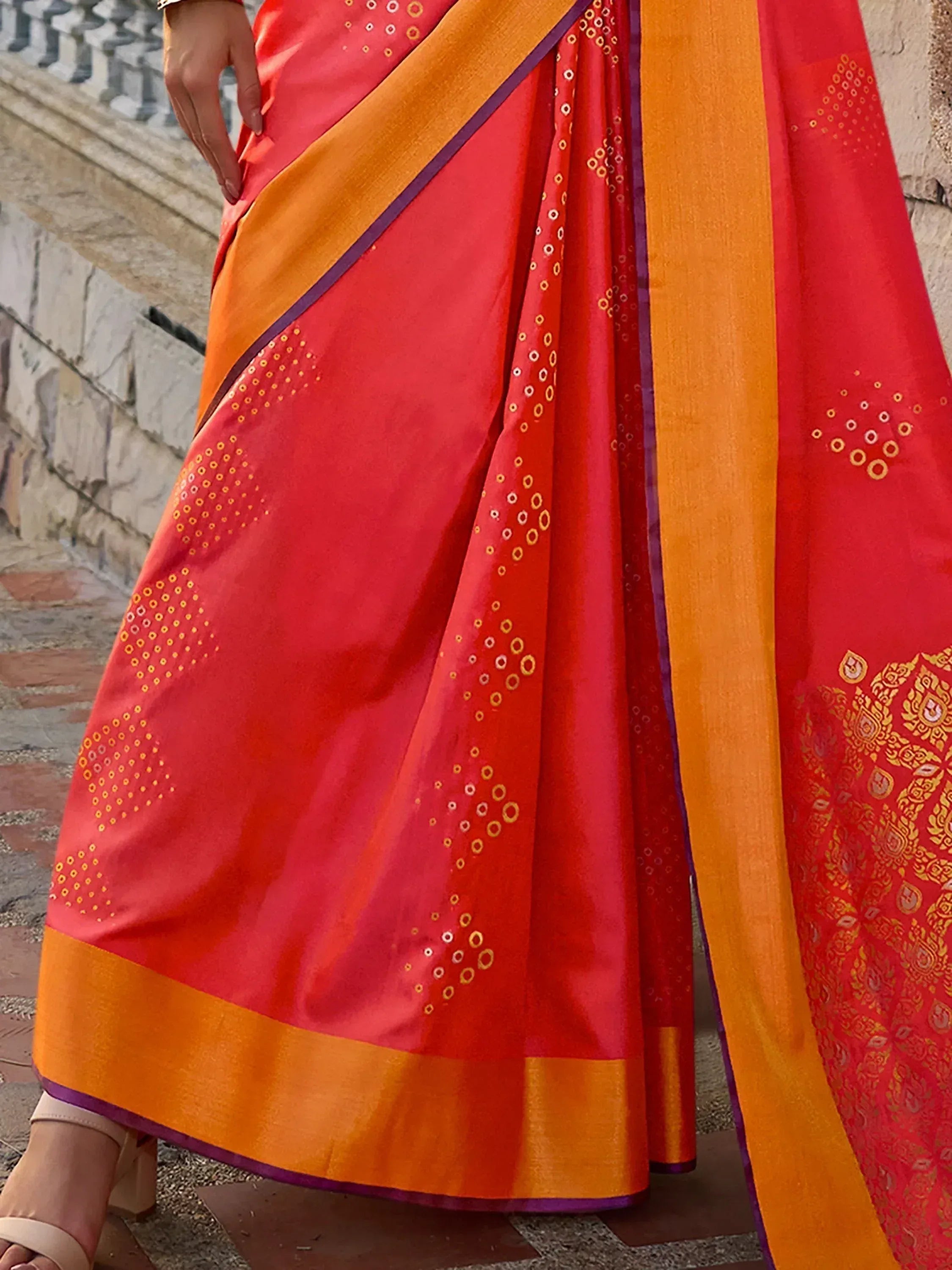 Vibrant red and orange saree with gold circular motifs and border, ideal for ethnic wear occasions.