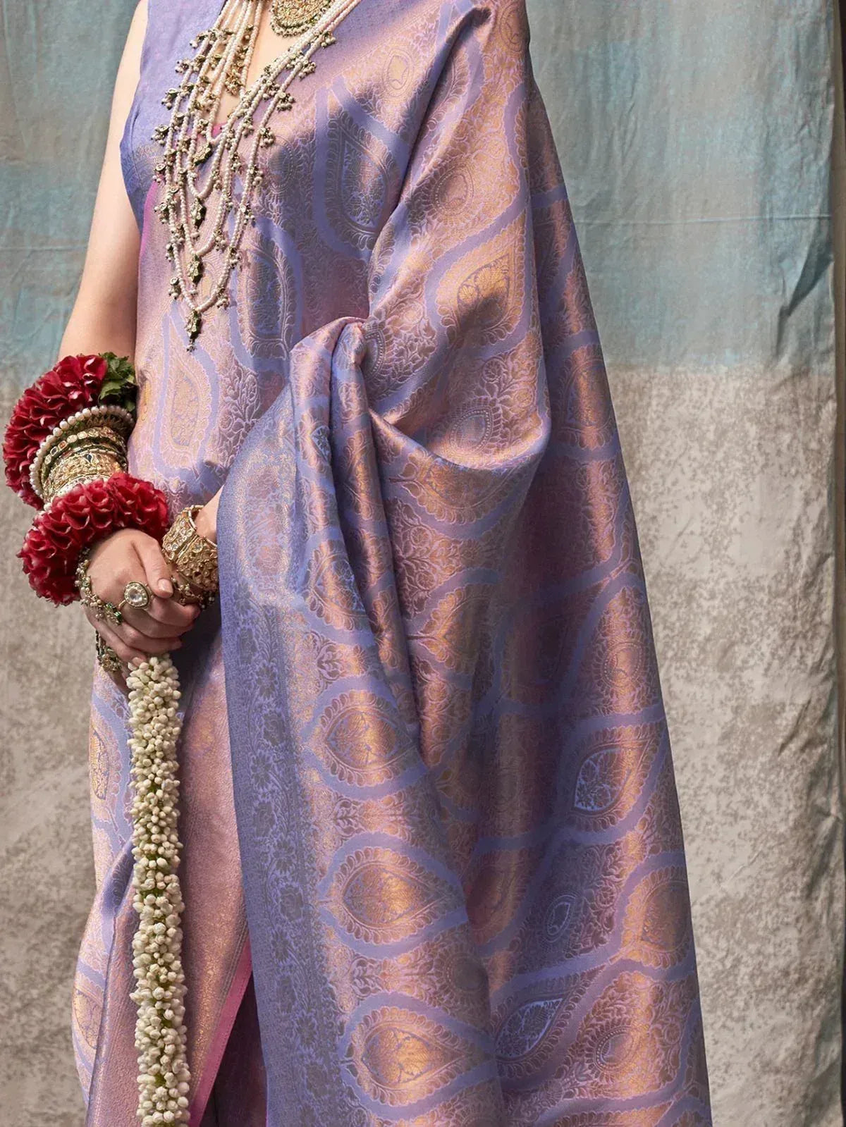 Purple and gold paisley saree with traditional jewelry and floral bangles, perfect for Indian ethnic occasions