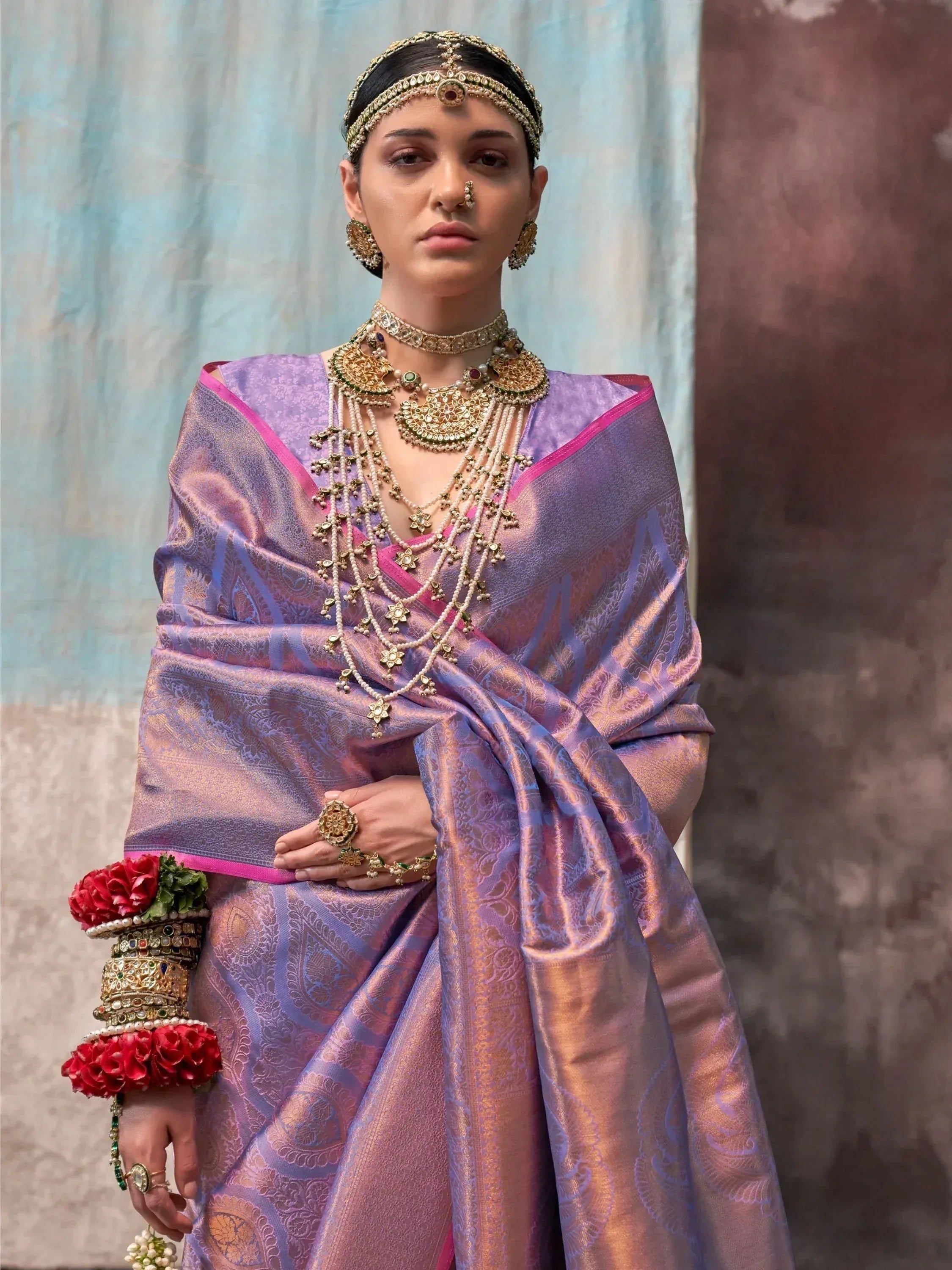 Woman in purple designer saree with gold jewelry, traditional Indian ethnic wear for weddings