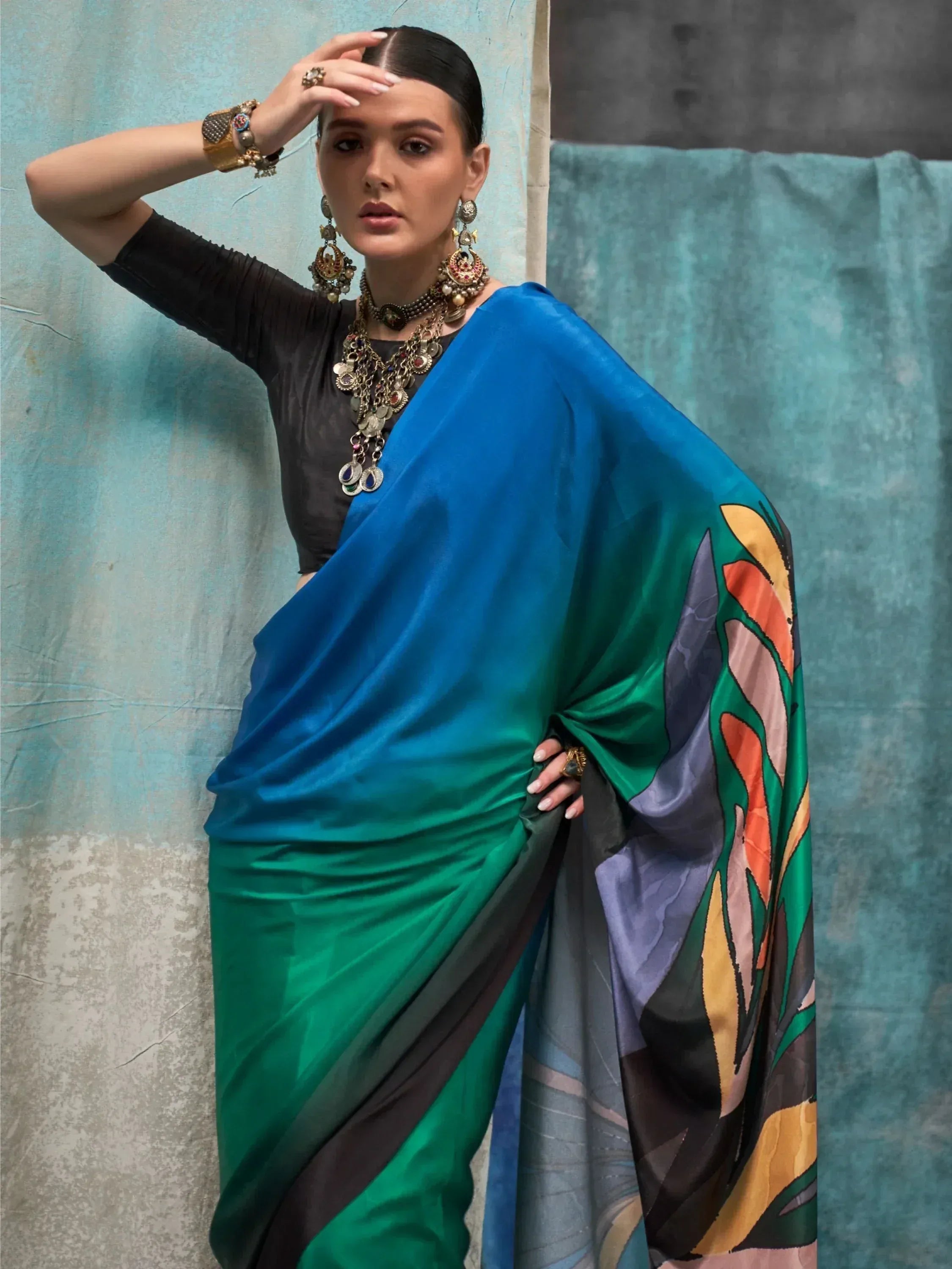 Woman in vibrant blue-green printed saree with ethnic jewelry, styled for Indian ethnic wear