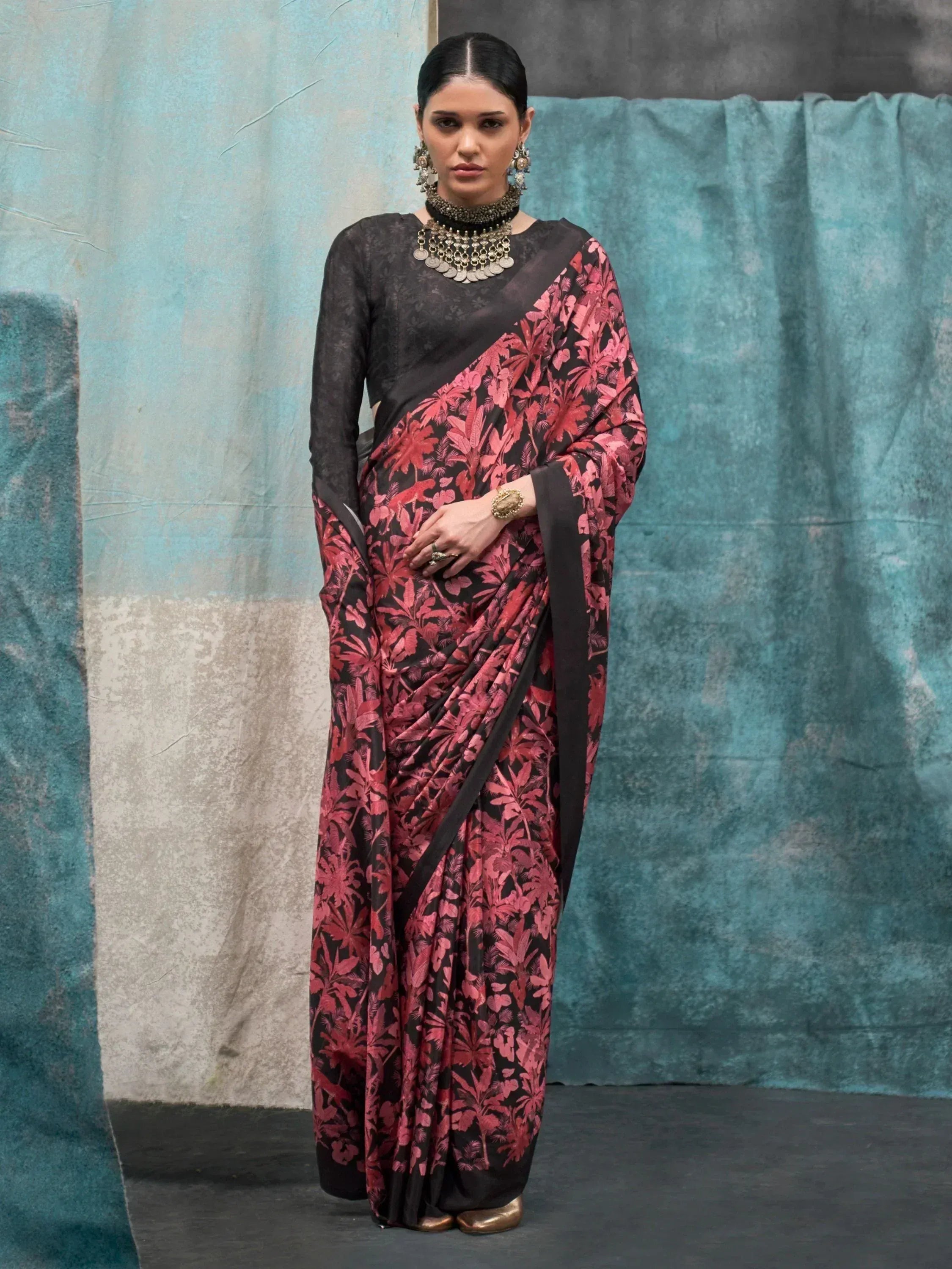 Black and pink floral print saree with matching blouse, styled with traditional jewelry for ethnic wear