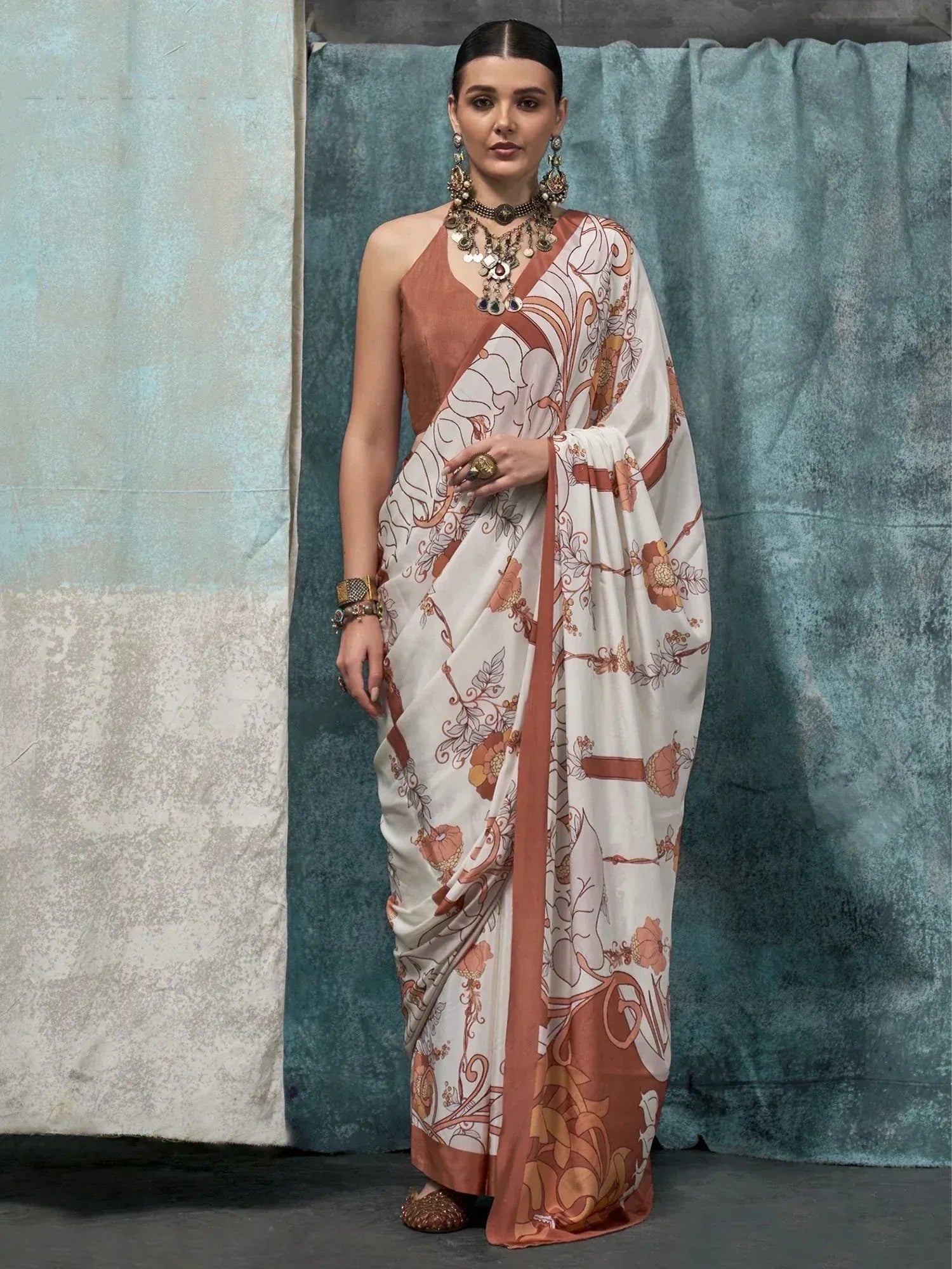 Elegant white saree with terracotta floral print, paired with matching blouse and traditional jewelry for ethnic wear.
