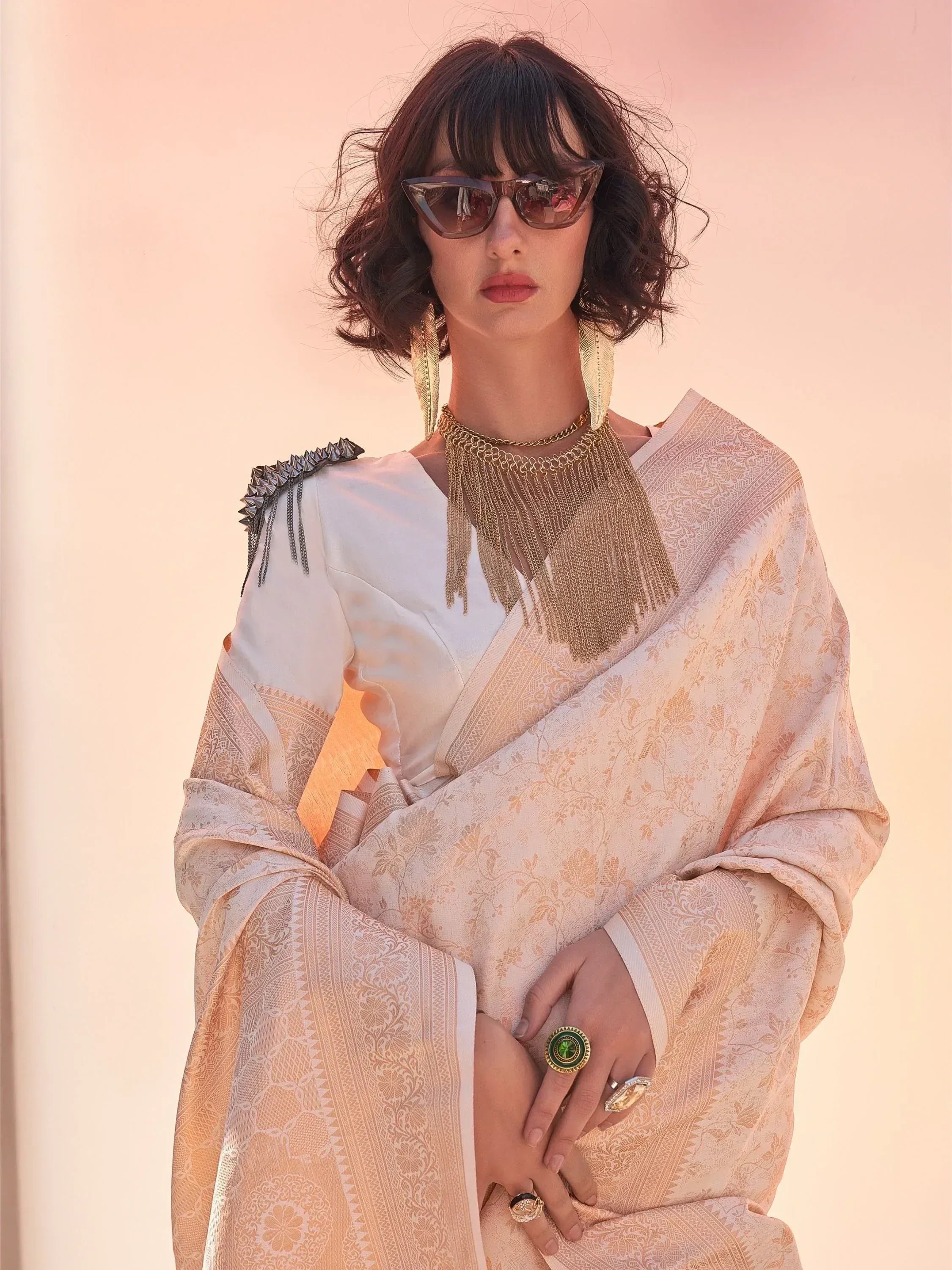 Stylish woman in designer ethnic gown with gold embroidery, statement jewelry, and sunglasses