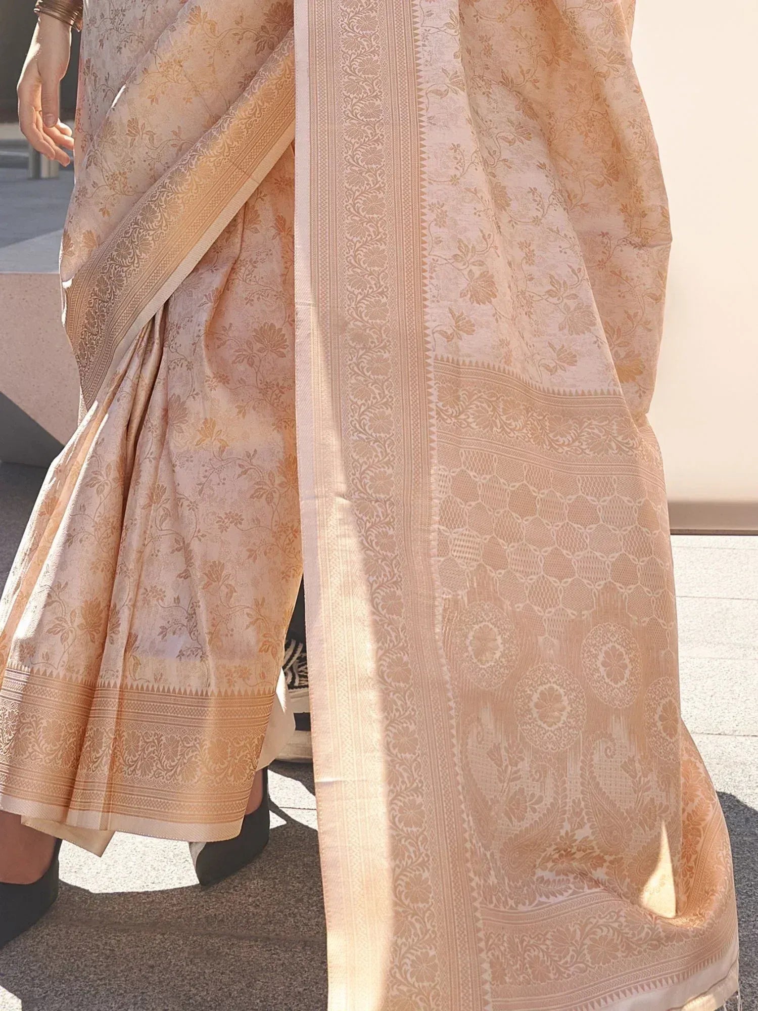 Elegant peach floral saree with intricate border, perfect for Indian ethnic wear occasions