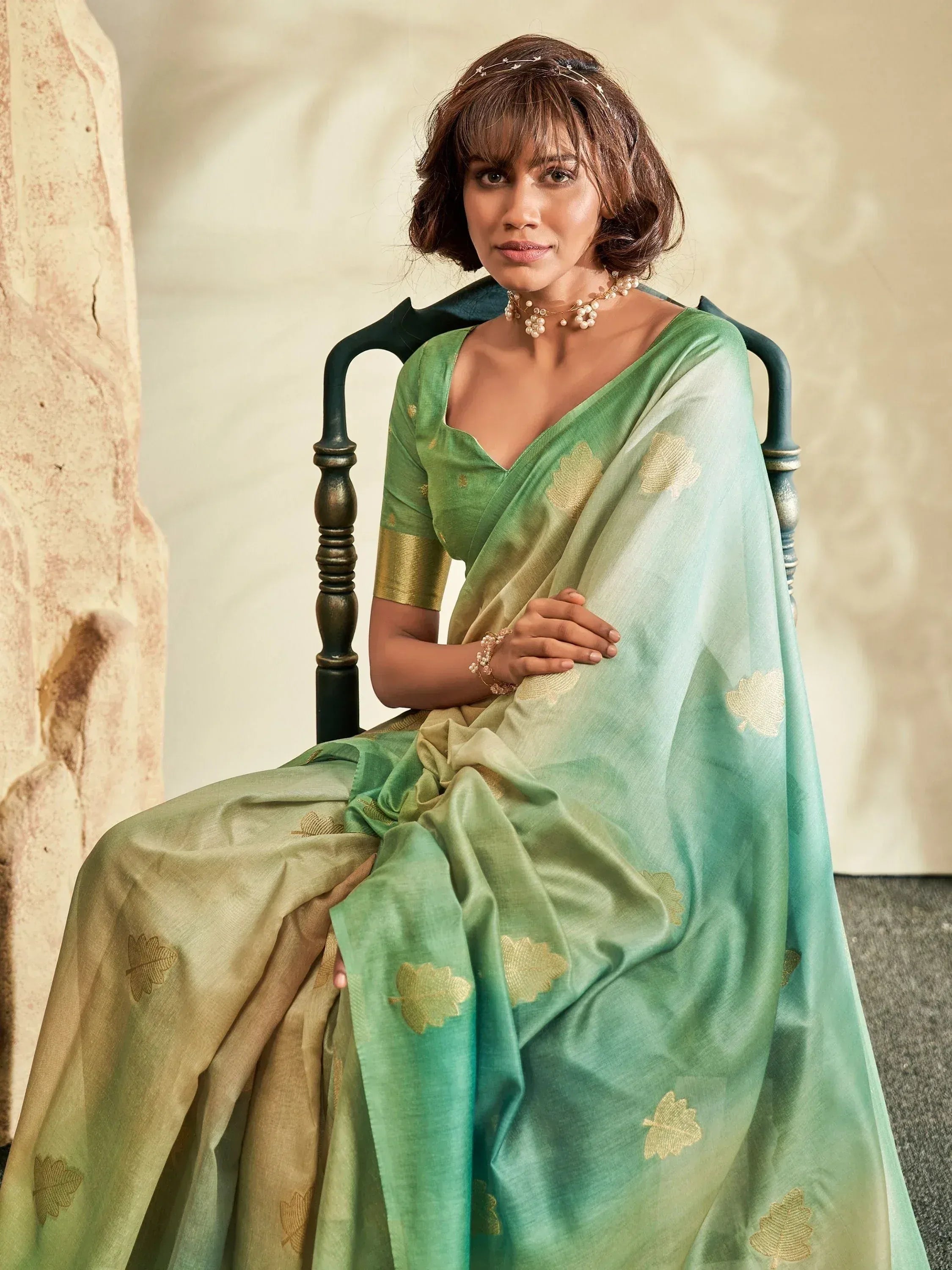 Woman in elegant green saree with gold leaf motifs, styled for Indian ethnic wear