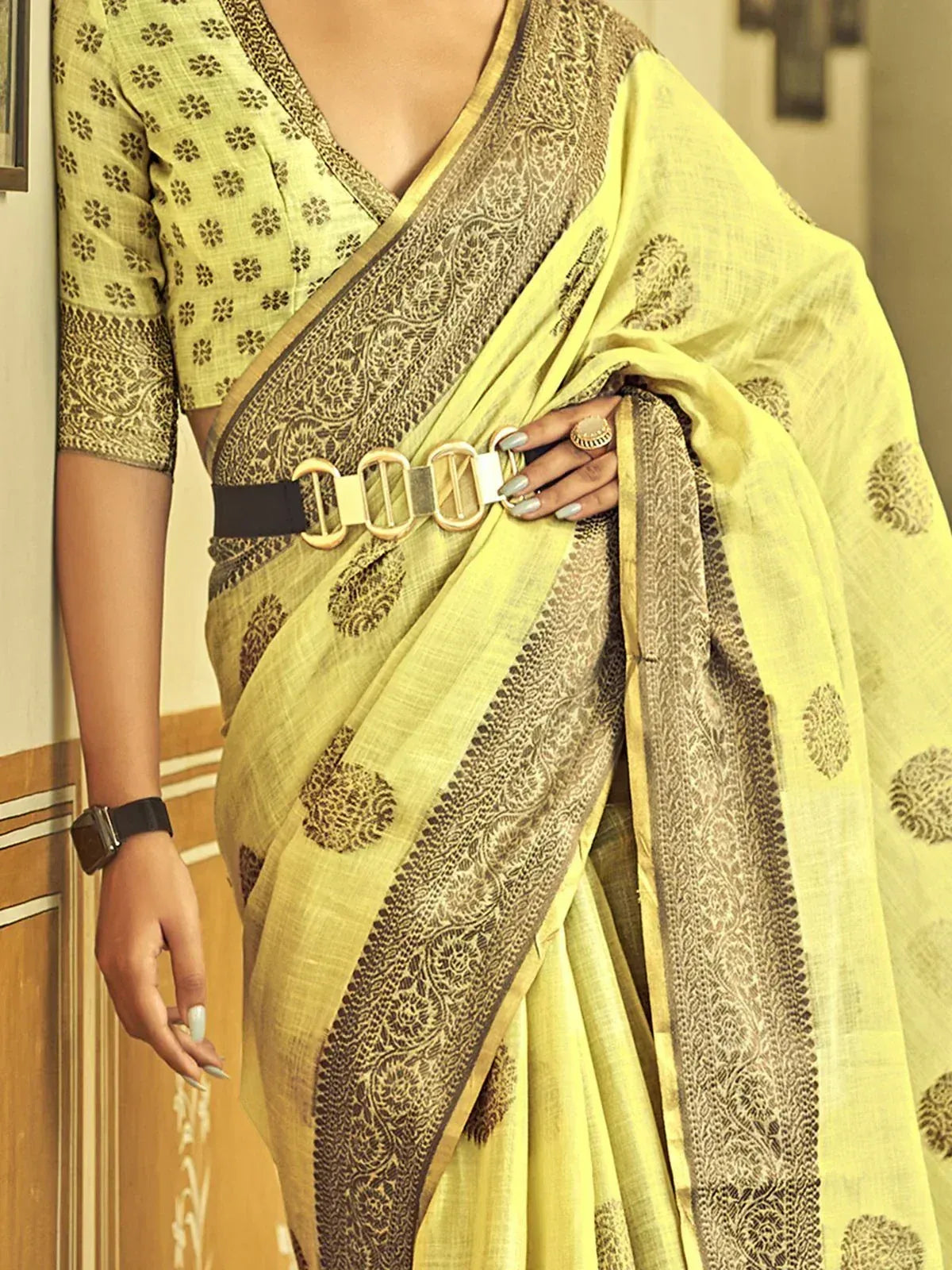 Yellow printed saree with black border, paired with matching blouse and belt, ideal for ethnic occasions