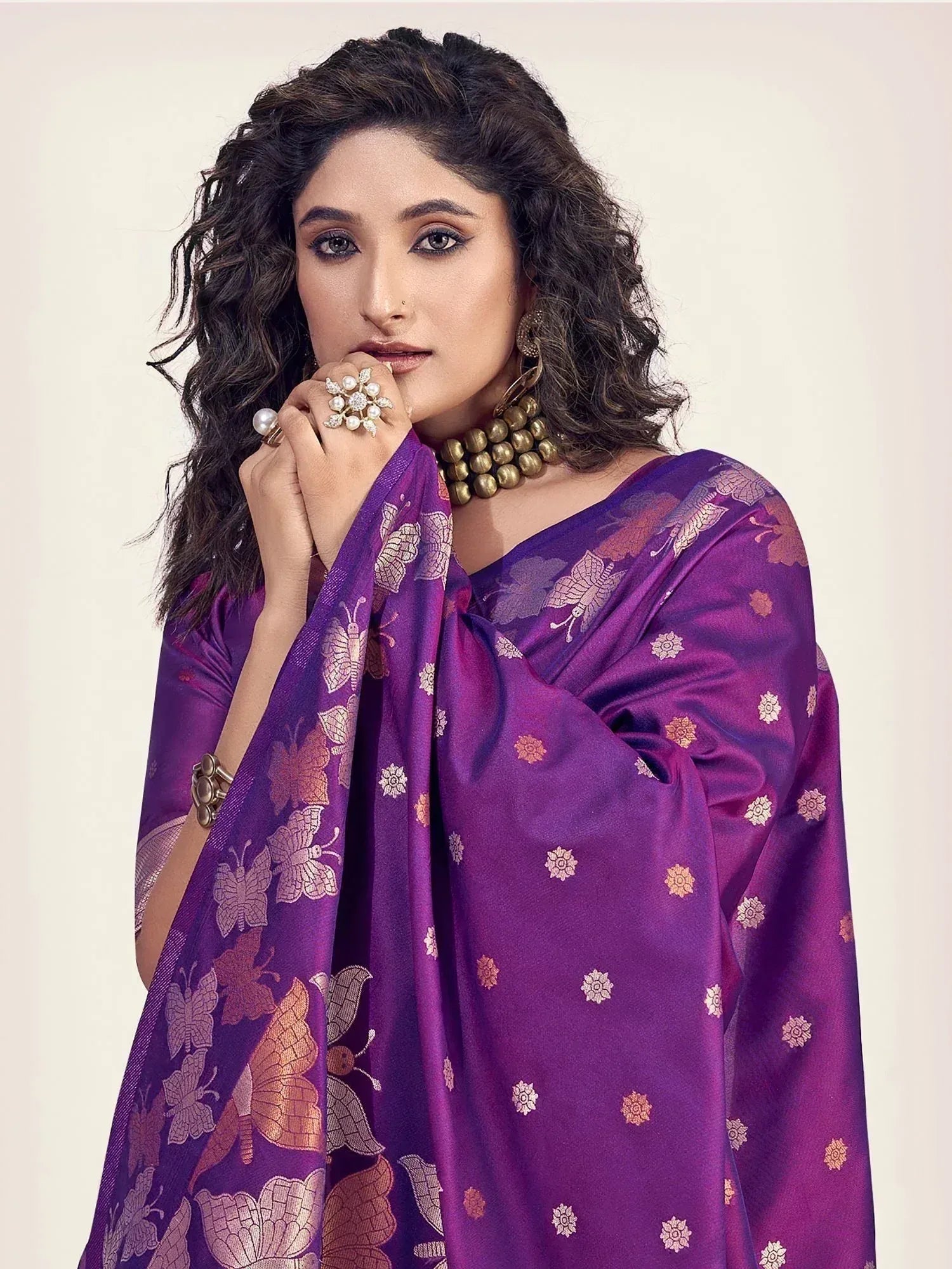 Purple butterfly print saree with gold floral motifs, styled with statement jewelry for ethnic occasions