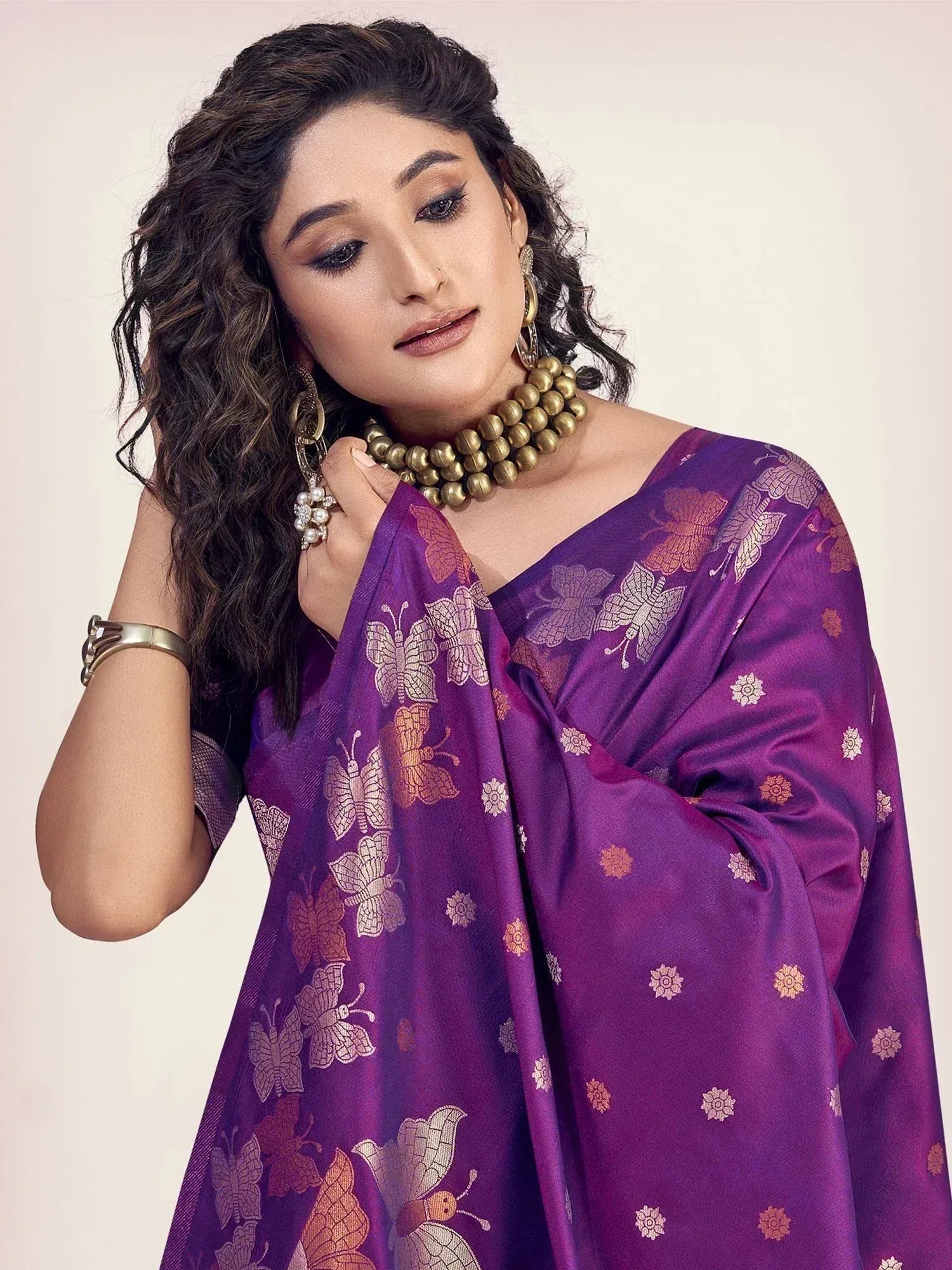 Purple ethnic saree with butterfly print, gold jewelry, and elegant styling for festive occasions