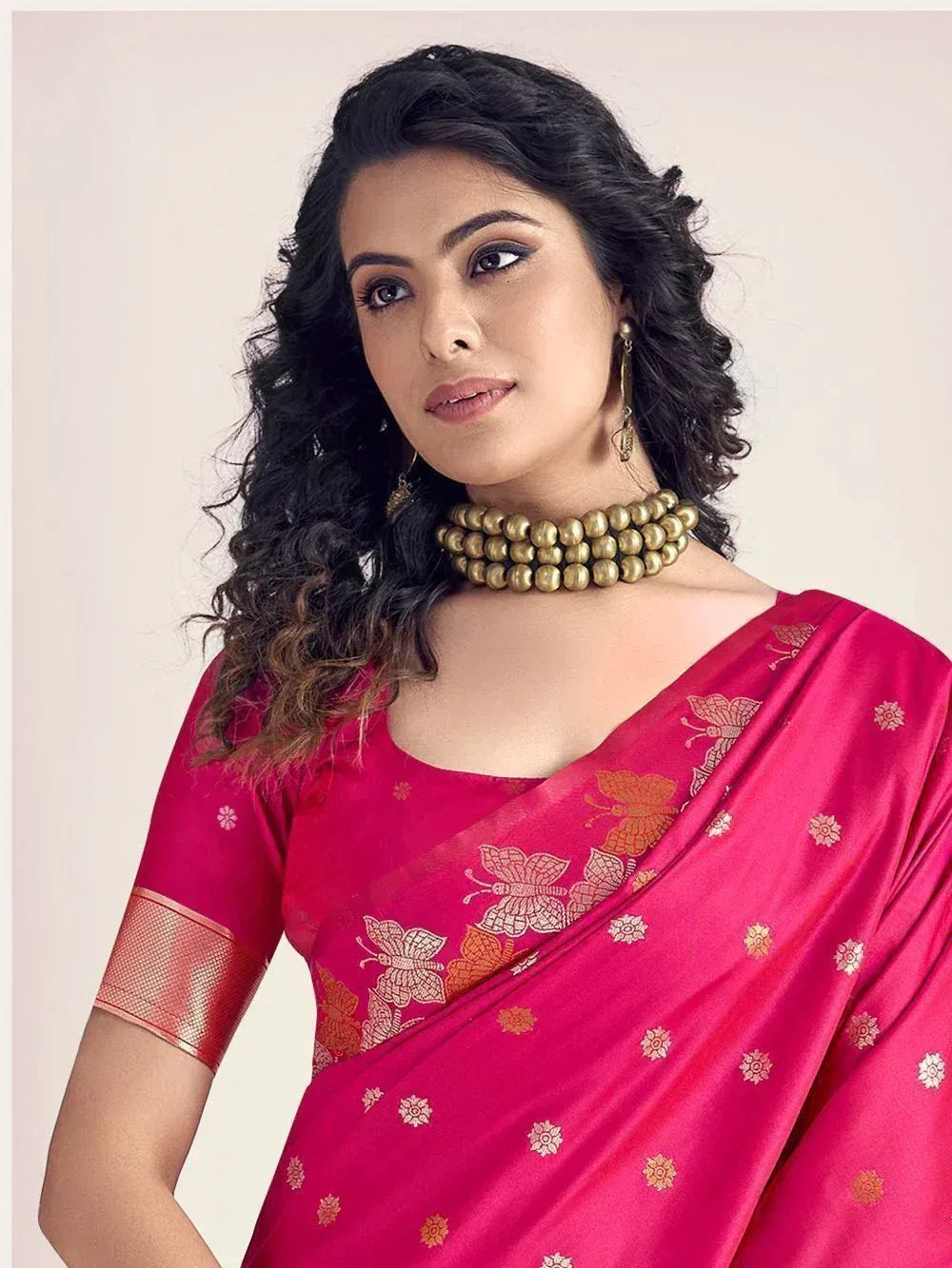 Pink saree with golden butterfly print and matching blouse, styled with gold choker necklace