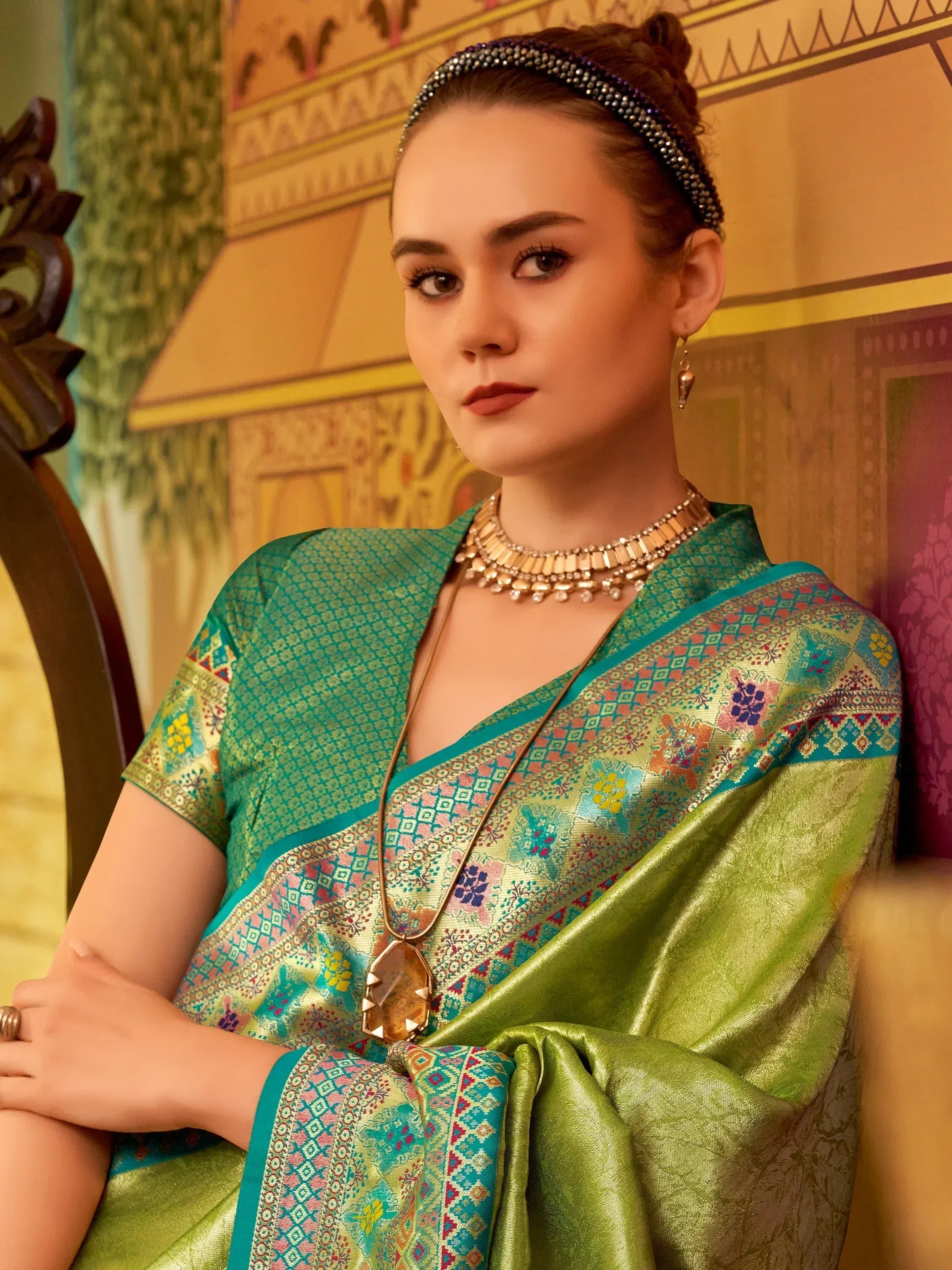 Elegant green saree with floral patterns, paired with traditional jewelry for festive occasions.