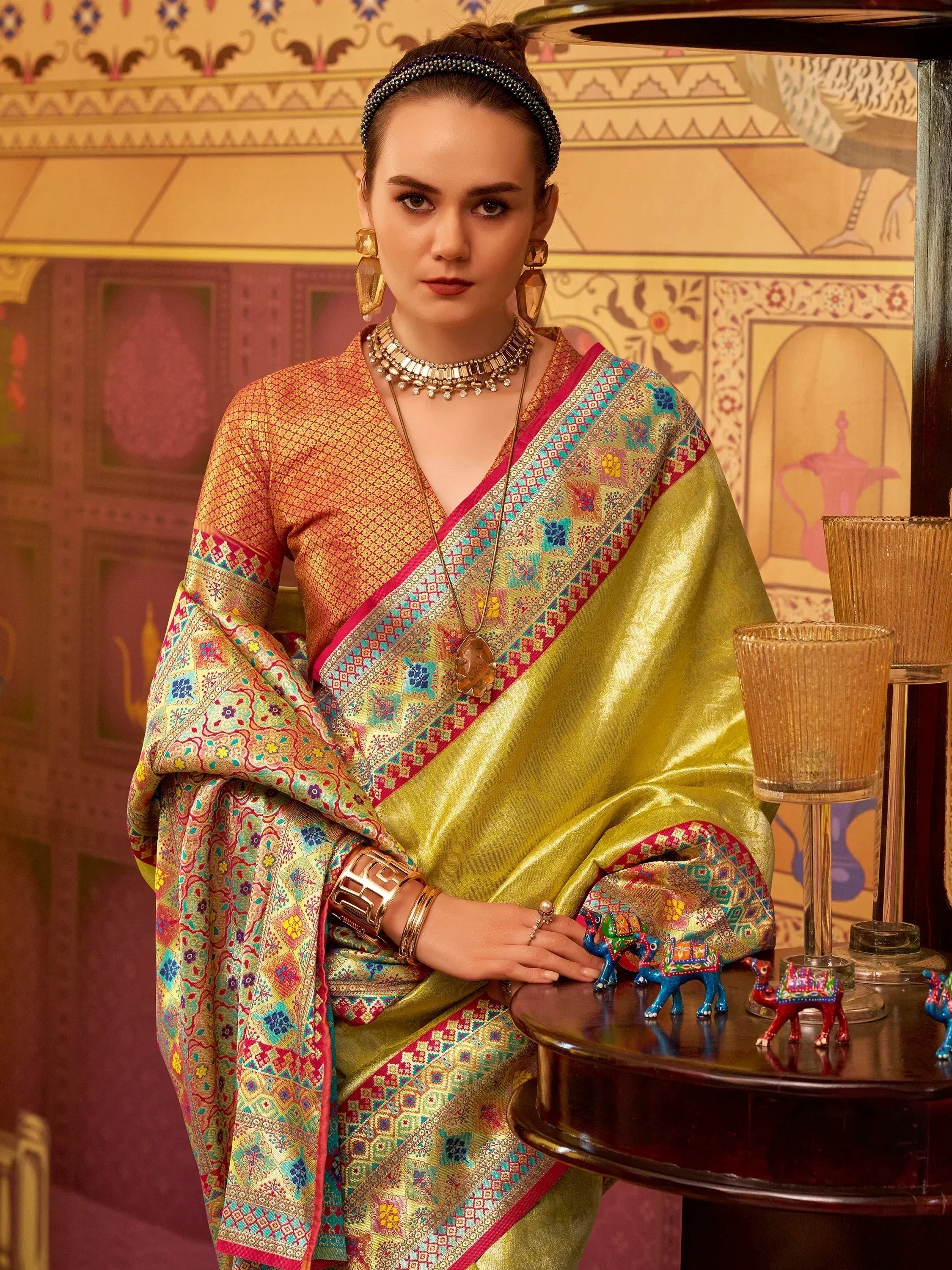 Elegant woman in vibrant Indian saree with intricate embroidery and traditional jewelry