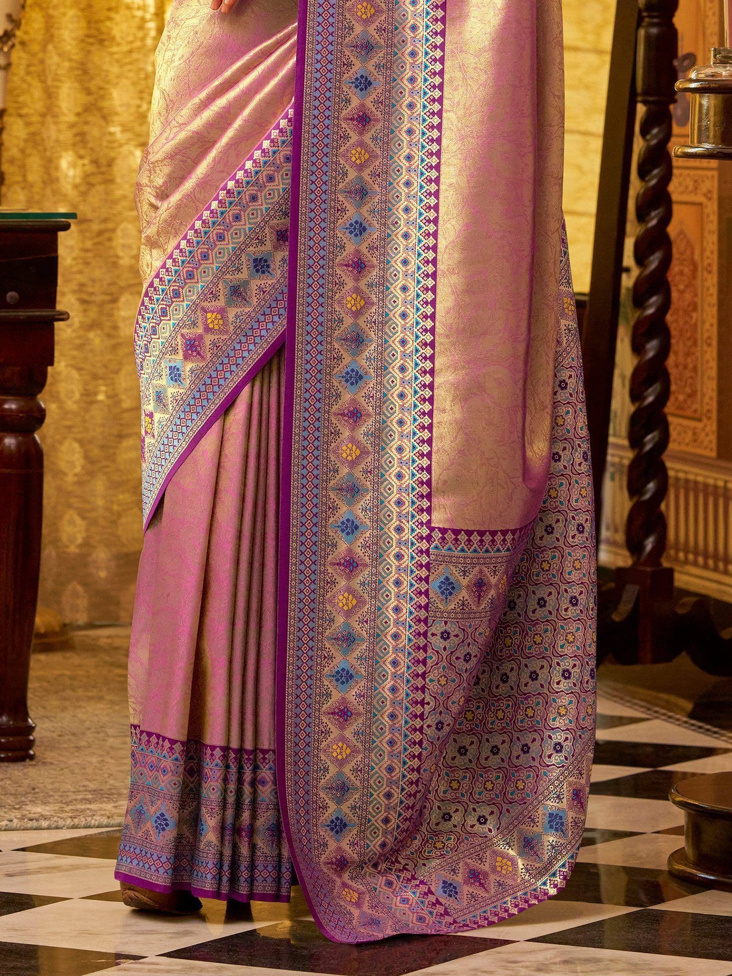 Elegant pink saree with intricate purple and blue geometric border designs, perfect for ethnic occasions.