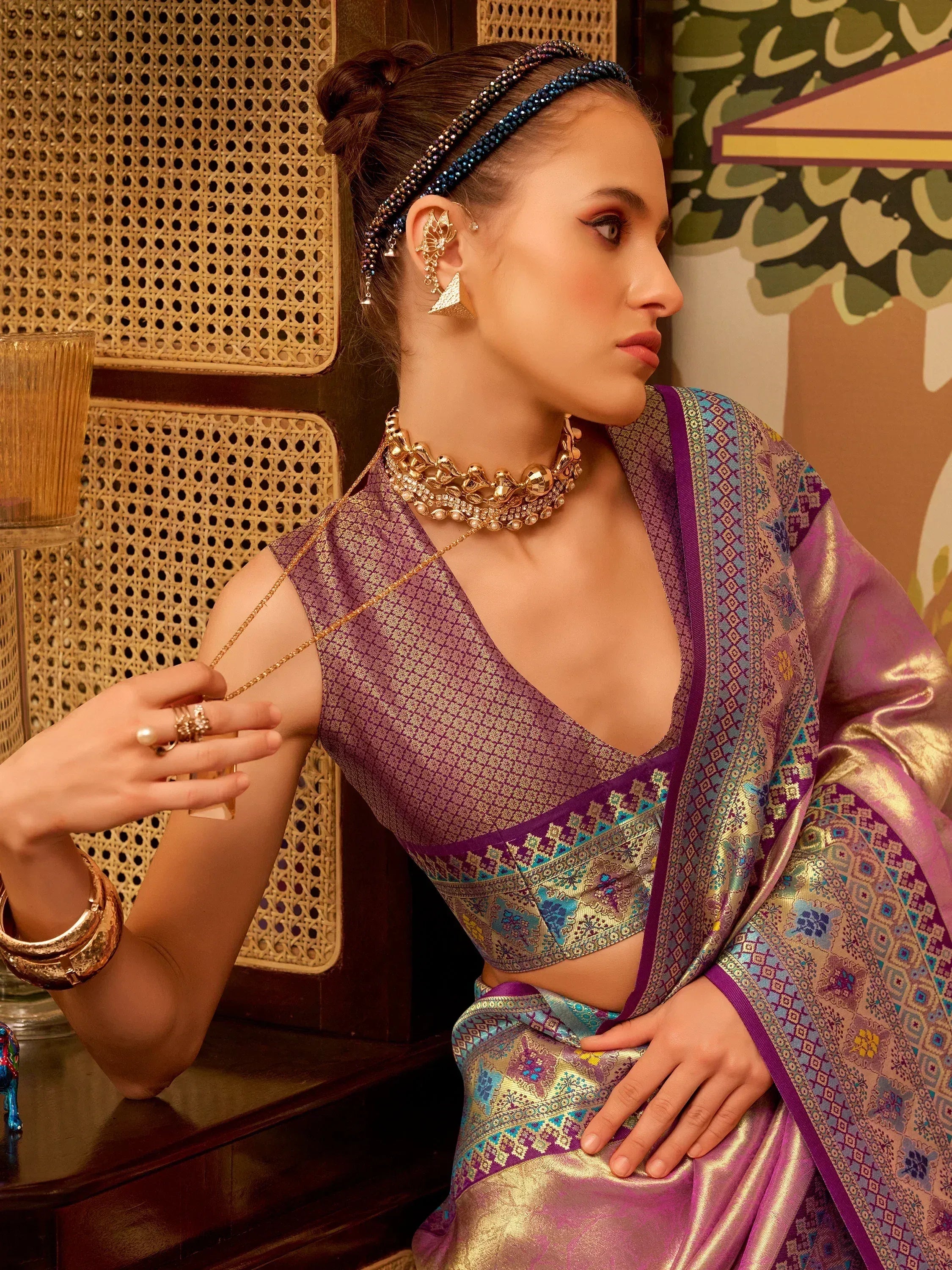 Elegant purple saree with intricate gold and blue patterns, paired with traditional jewelry