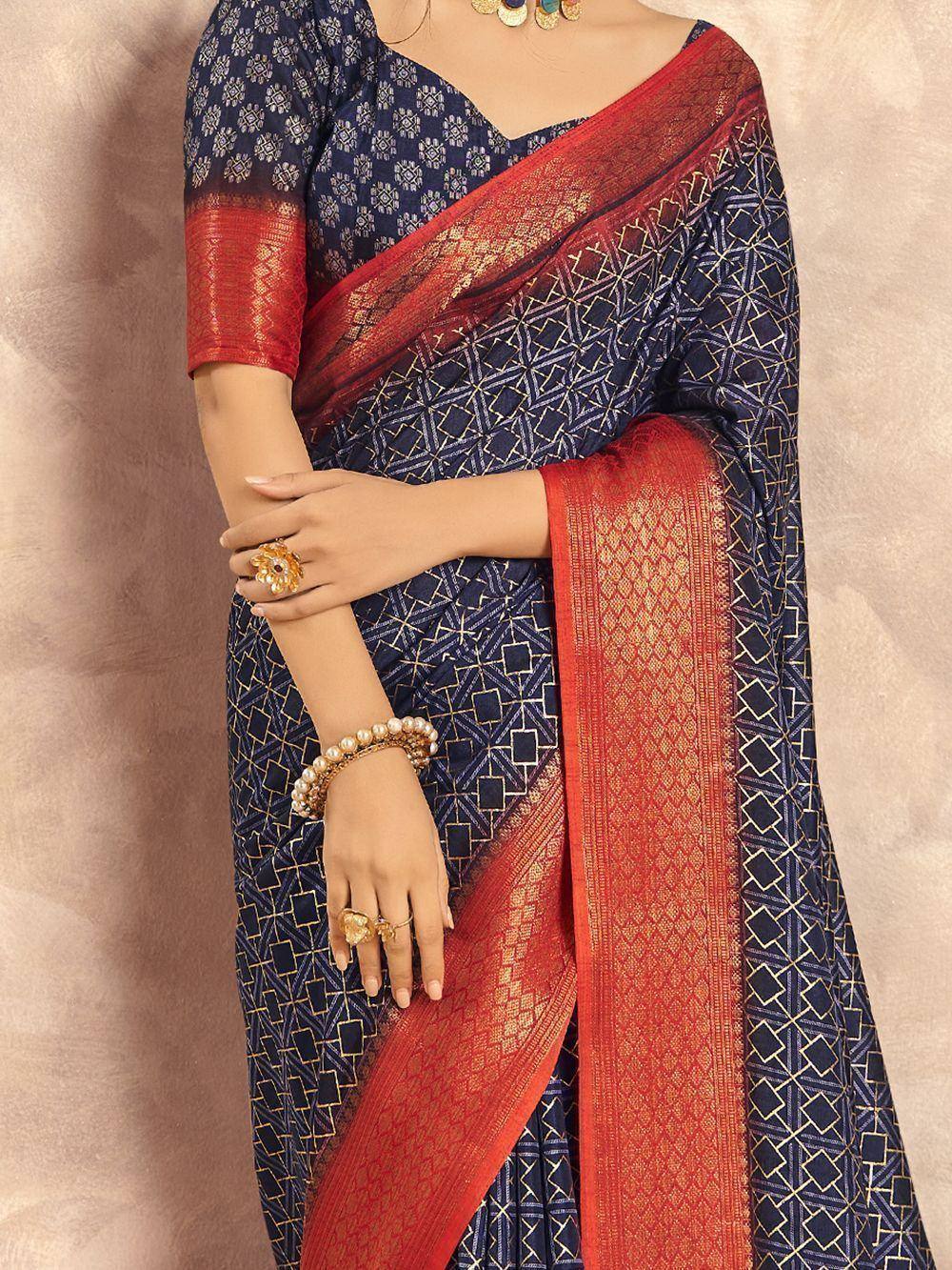 Navy blue saree with gold geometric print and red border, paired with matching blouse for ethnic wear