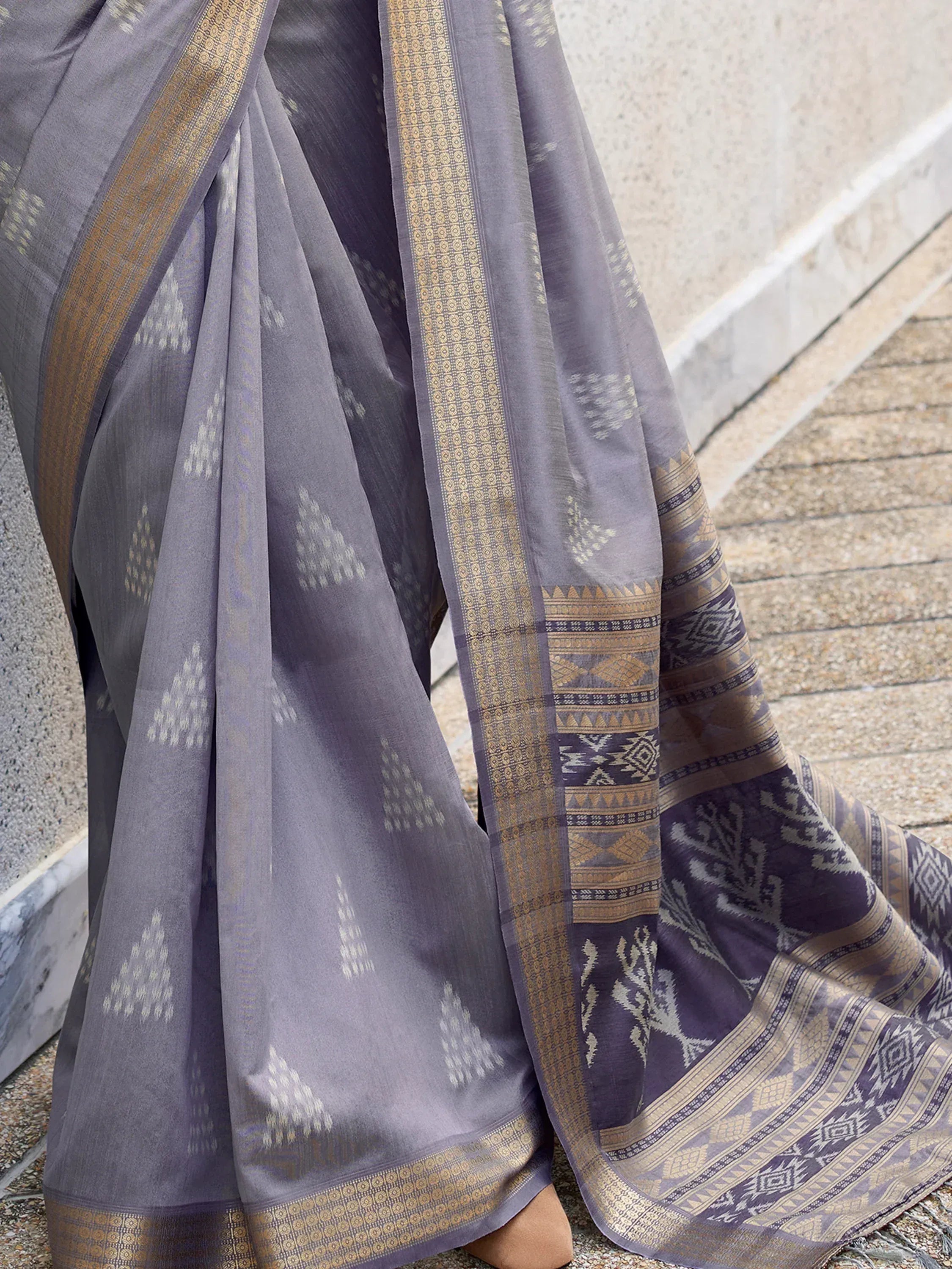 Grey ethnic saree with gold border and geometric ikat patterns, perfect for Indian occasions