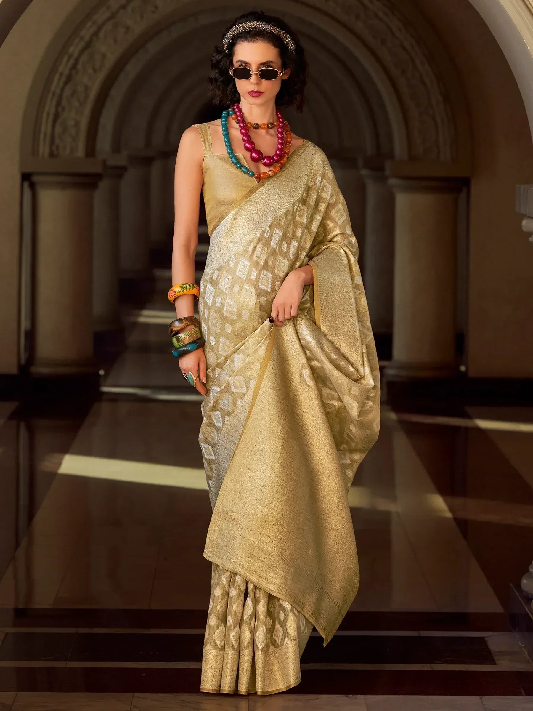 Golden designer saree with geometric pattern, styled with statement jewelry and sunglasses for ethnic wear