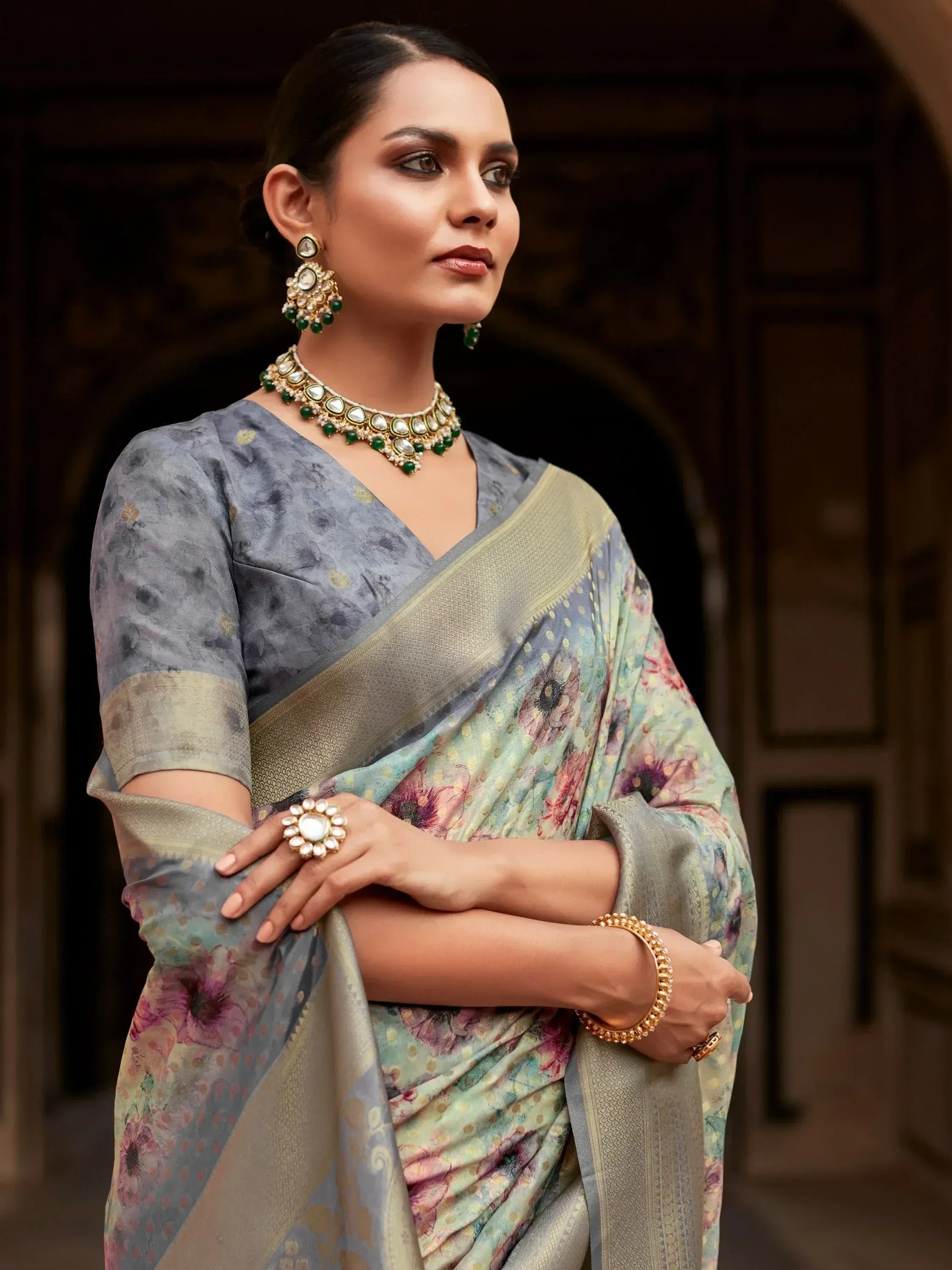 Woman in floral printed saree with gold border, paired with traditional Indian jewelry for ethnic wear