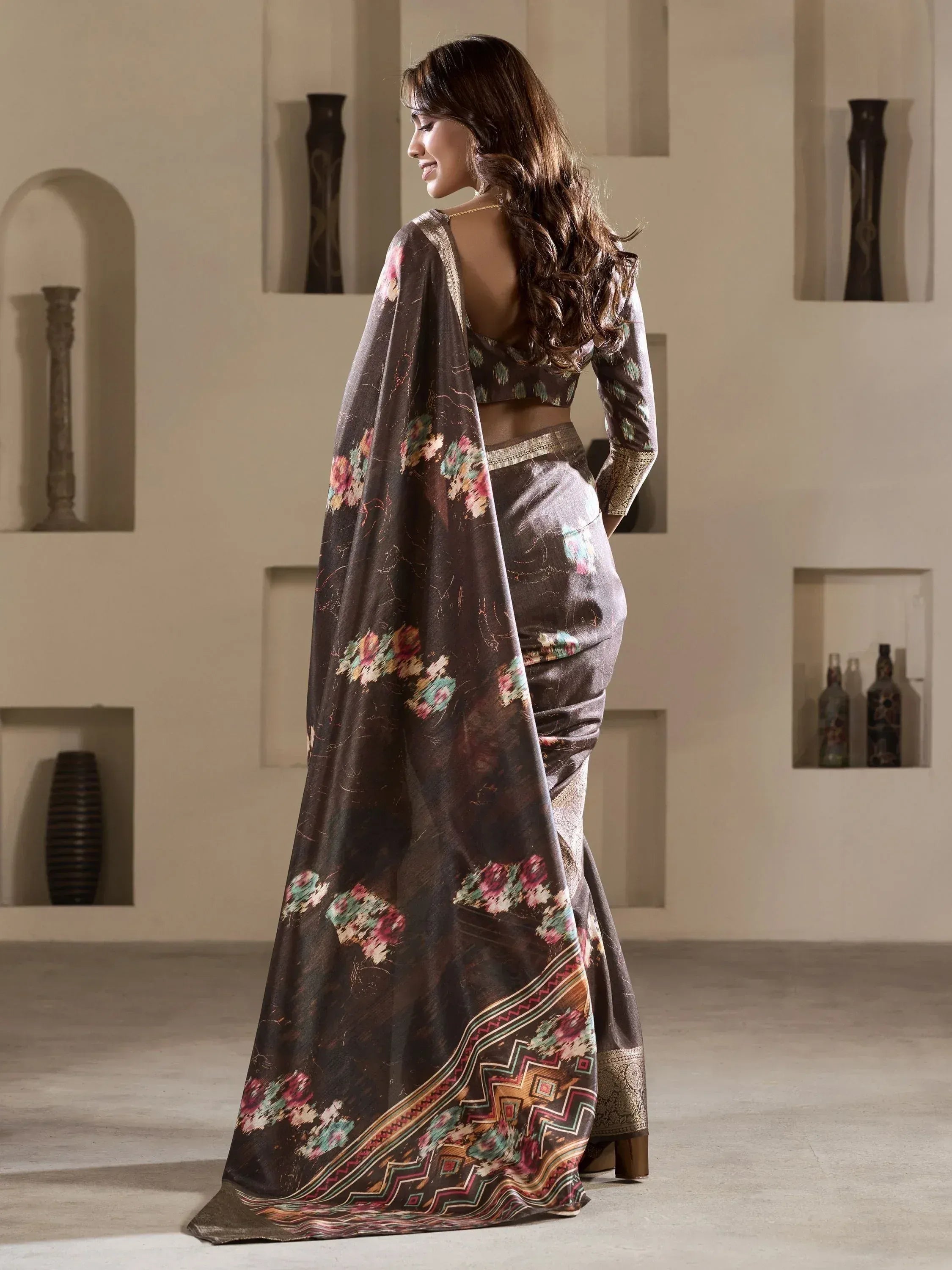 Woman in elegant brown floral saree with gold border, showcasing Indian ethnic wear style