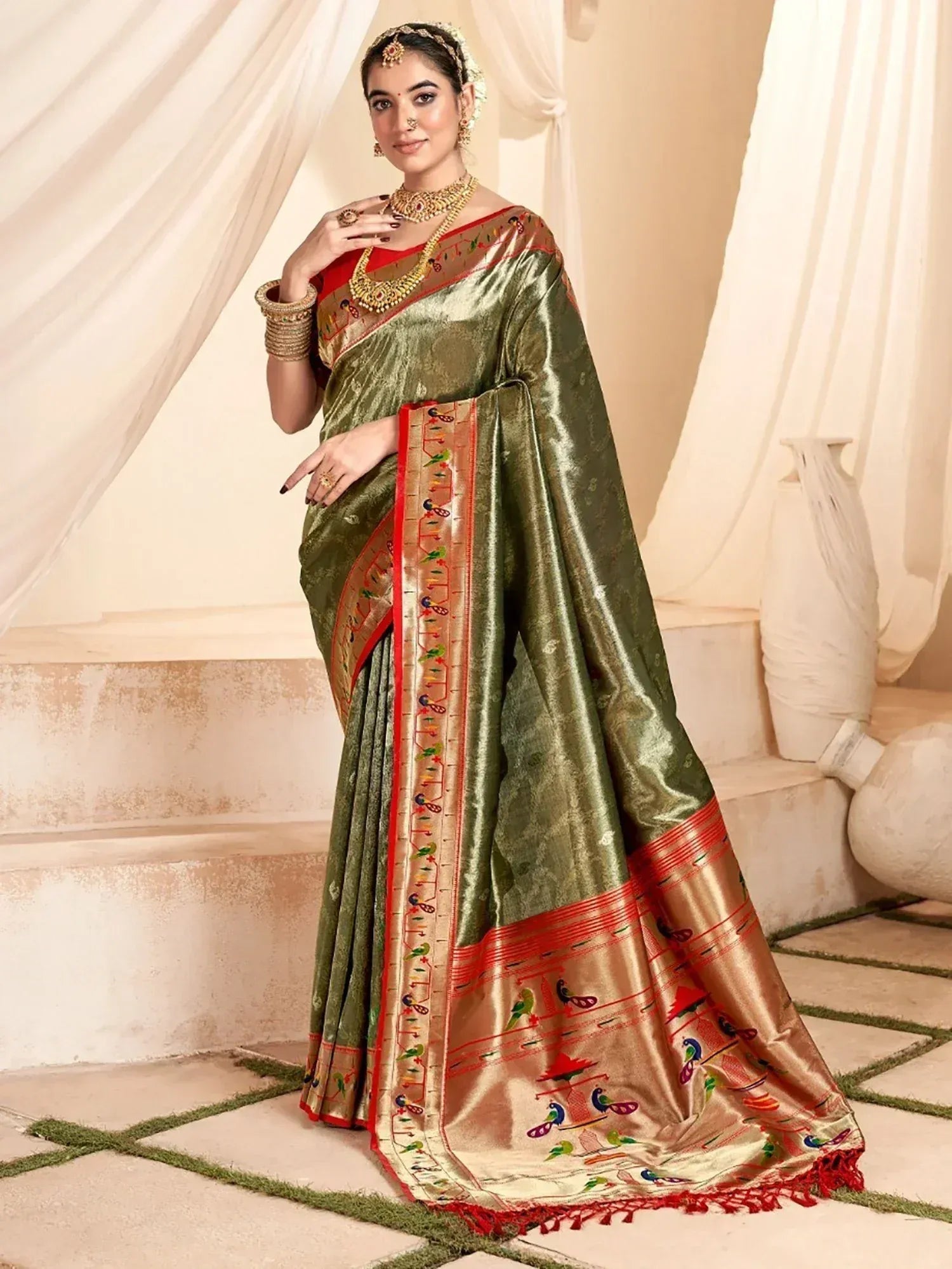 Olive green silk saree with peacock embroidery, red border, and gold jewelry for Indian ethnic wear
