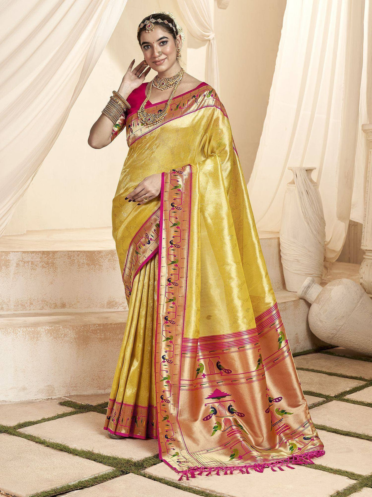 Yellow silk saree with pink border and bird motifs, paired with matching blouse, ideal for Indian ethnic occasions.