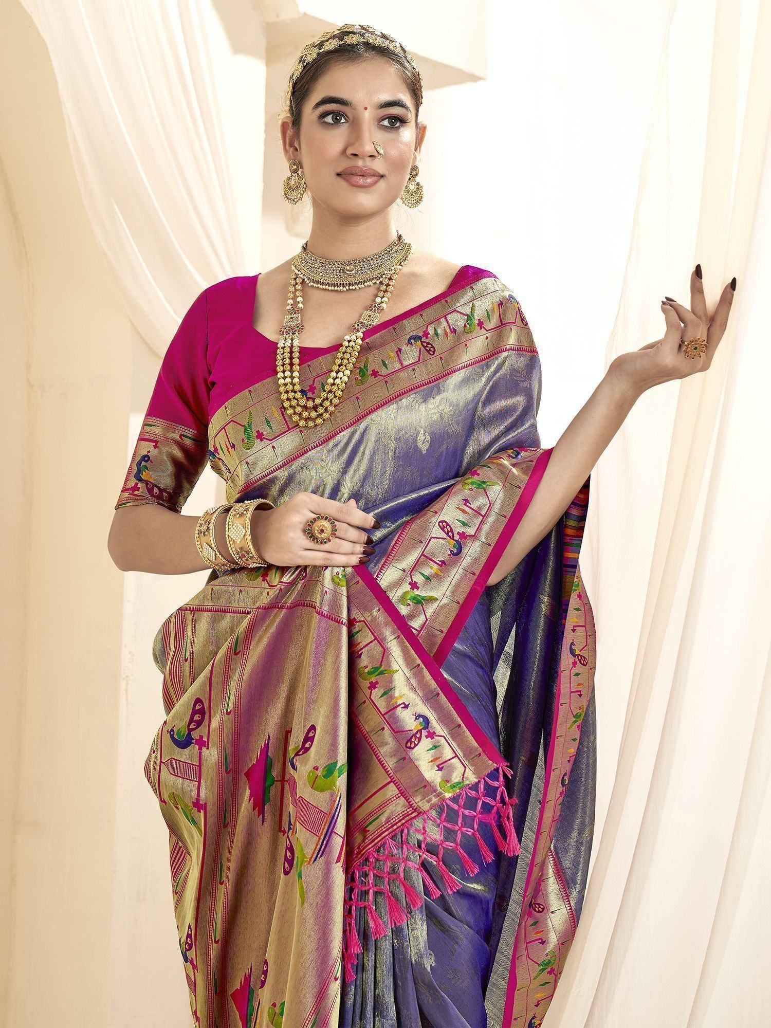 Woman in purple and gold embroidered saree with peacock motifs, pink blouse, and traditional jewelry