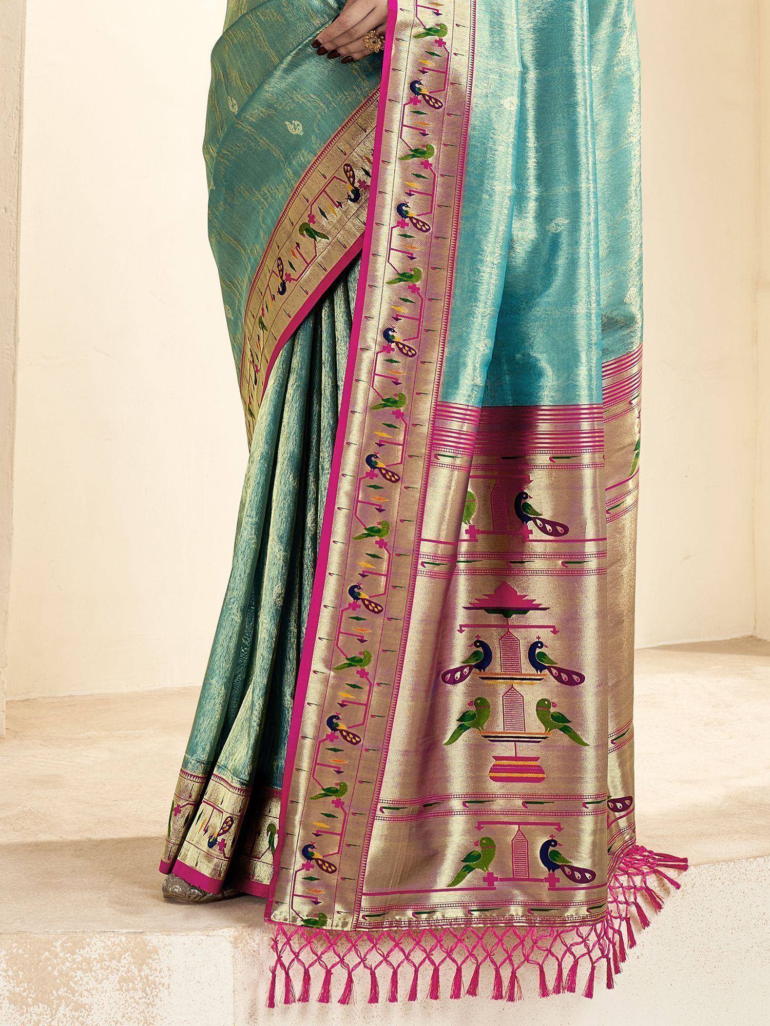 Teal silk saree with peacock motifs, pink border, and tassels, ideal for ethnic occasions
