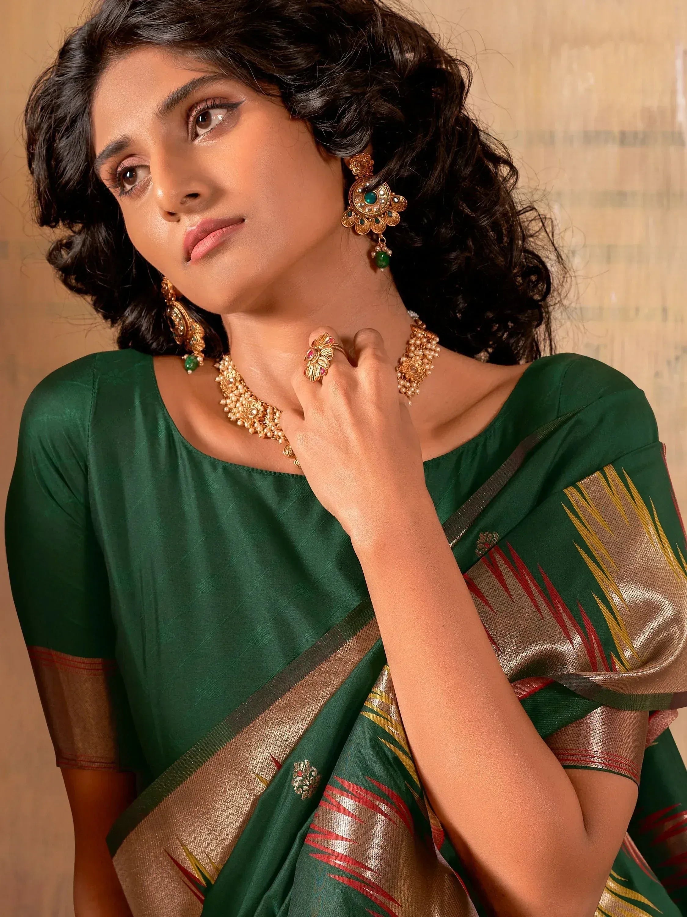 Woman in green Indian saree with gold jewelry, traditional ethnic wear for festive occasions