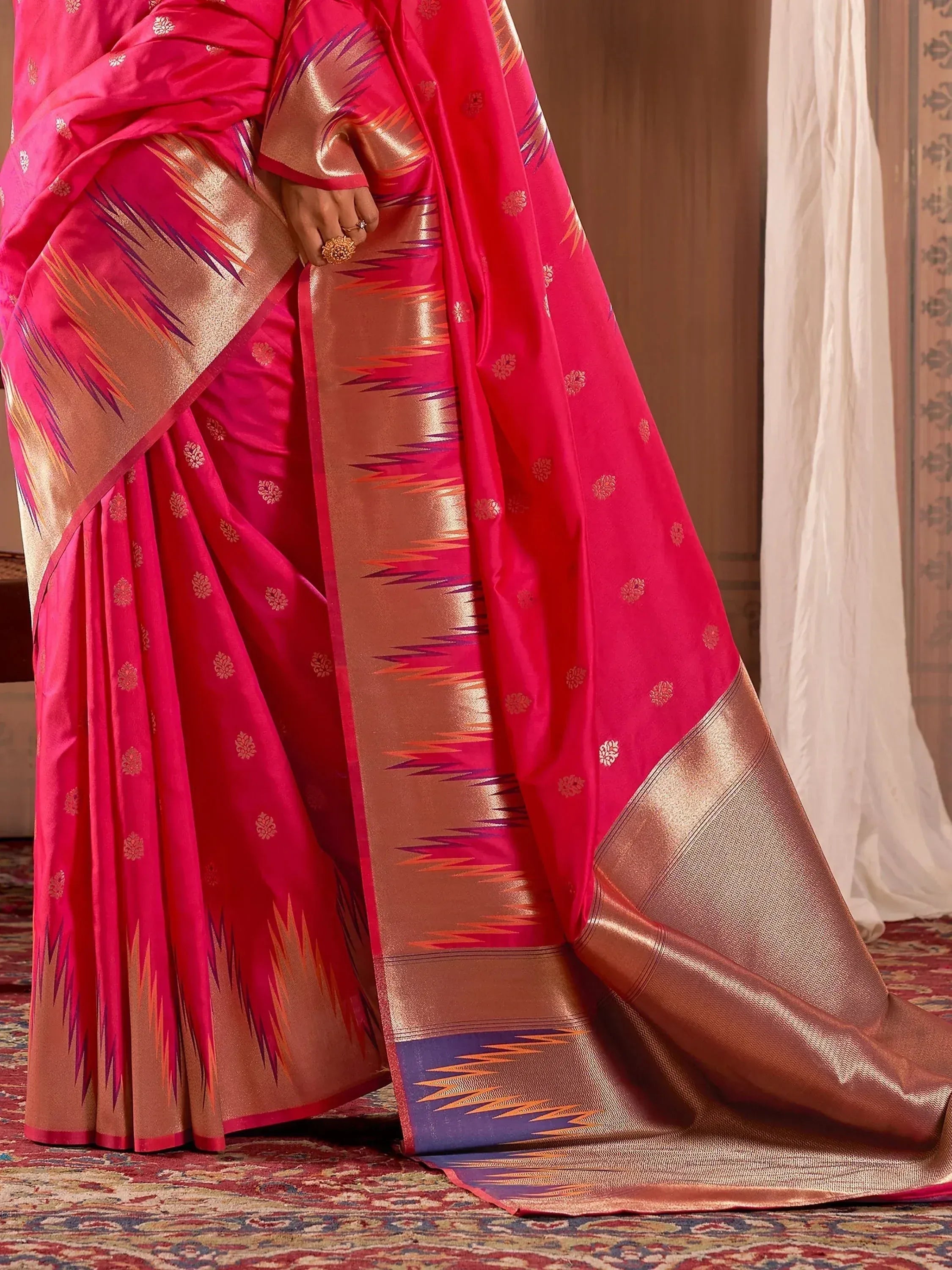 Vibrant pink ethnic saree with gold floral motifs and woven border, perfect for Indian occasions