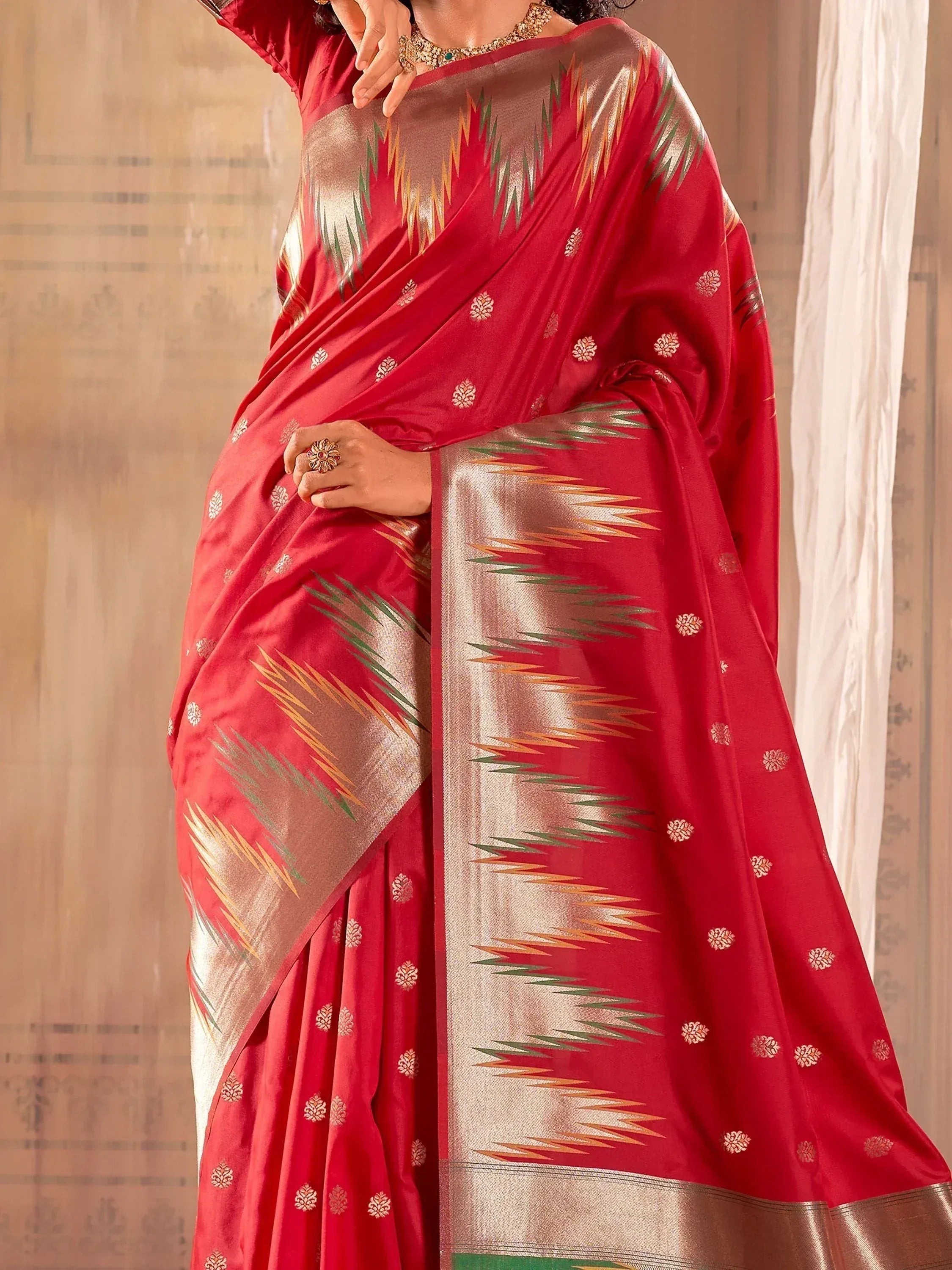 Red ethnic saree with gold and green ikat border, perfect for Indian occasions