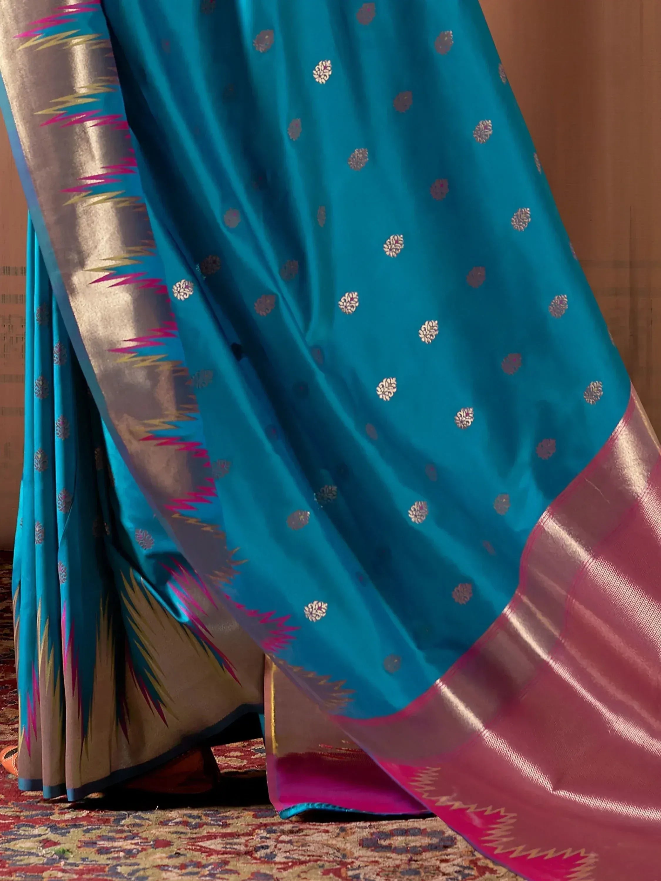 Teal silk saree with gold floral motifs and pink border, elegant Indian ethnic wear