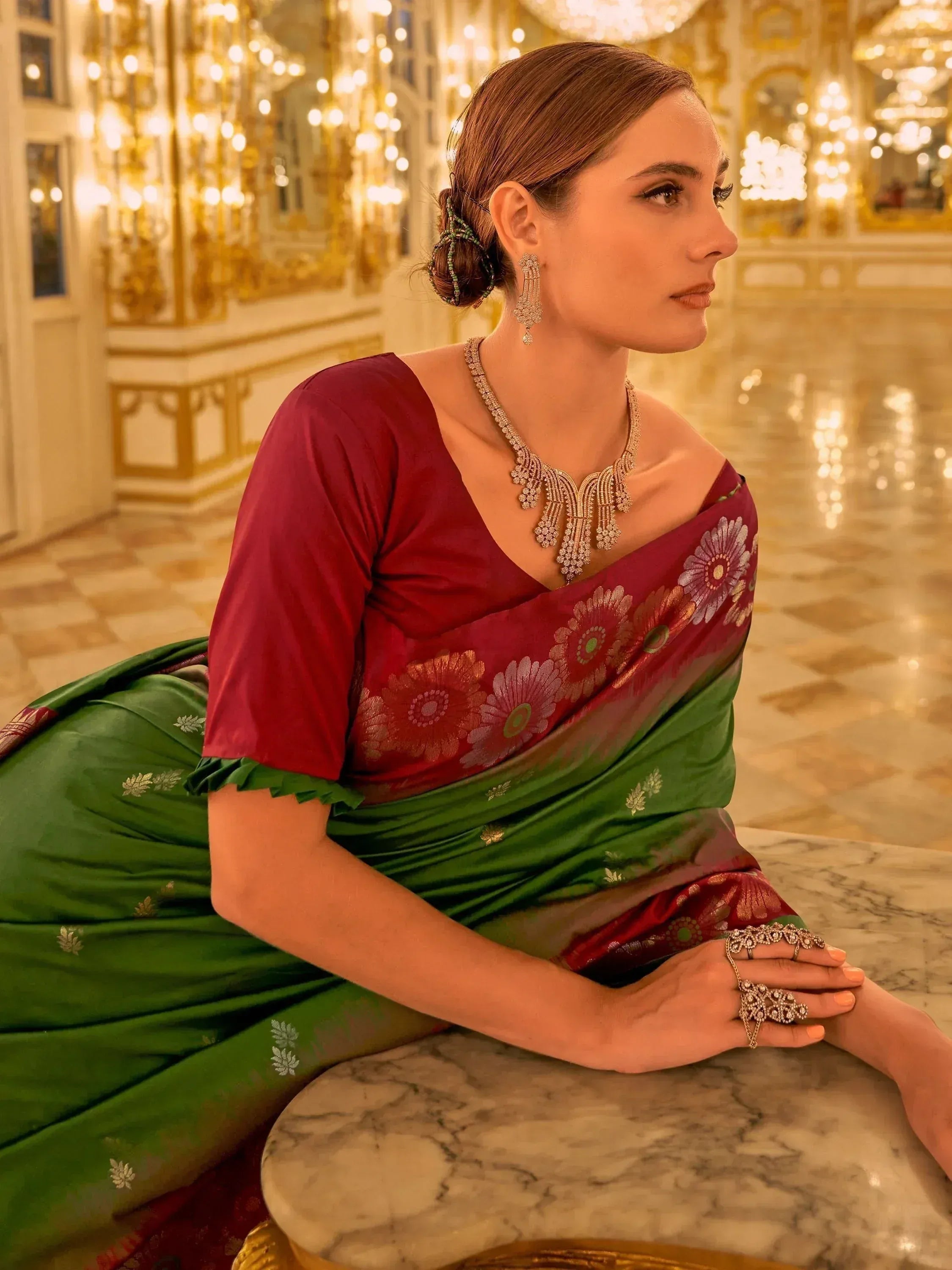 Woman in elegant red and green floral saree with gold jewelry, styled for festive Indian ethnic wear