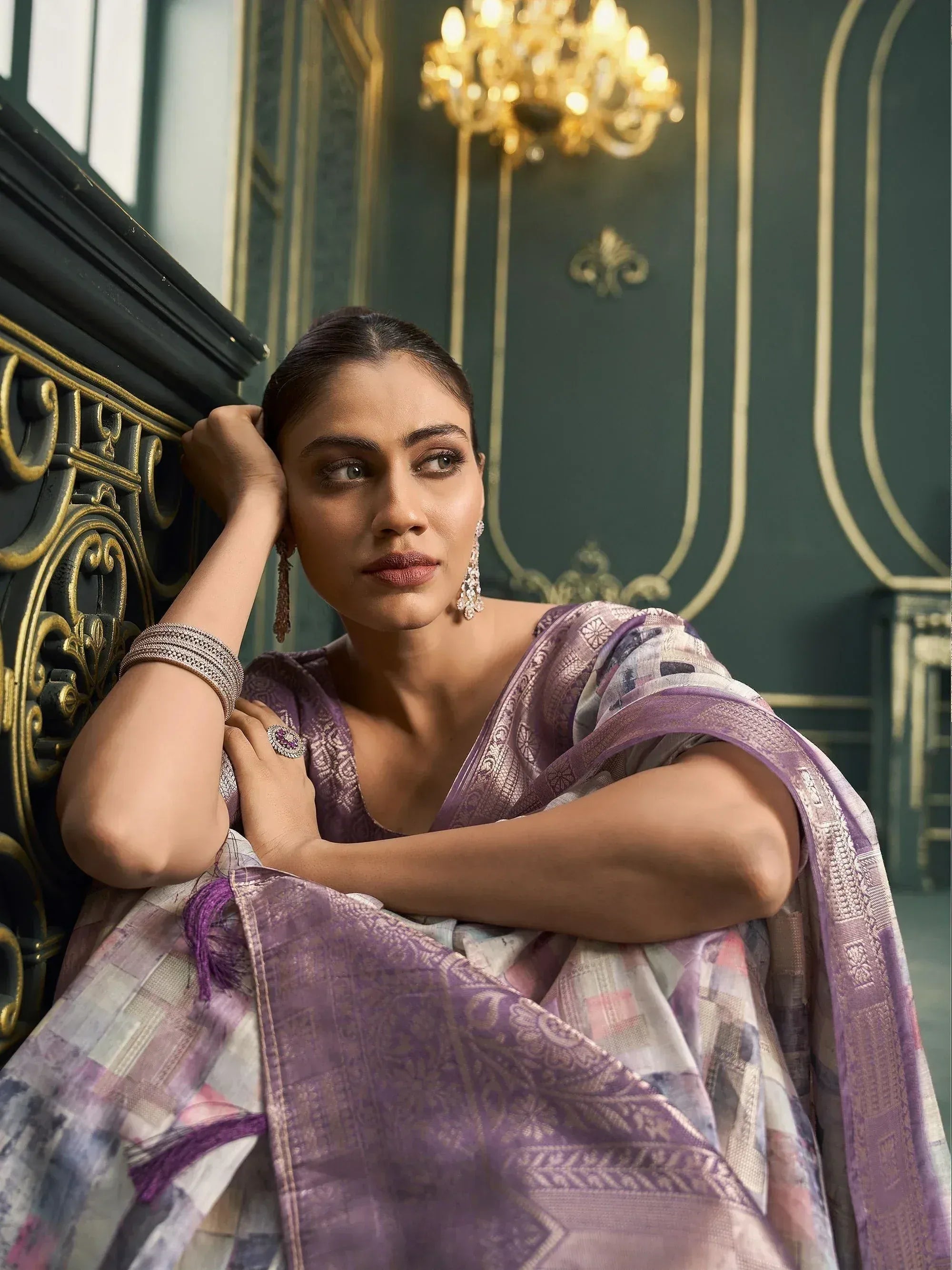 Woman in elegant purple printed saree with gold embroidery, styled with traditional jewelry for ethnic occasions