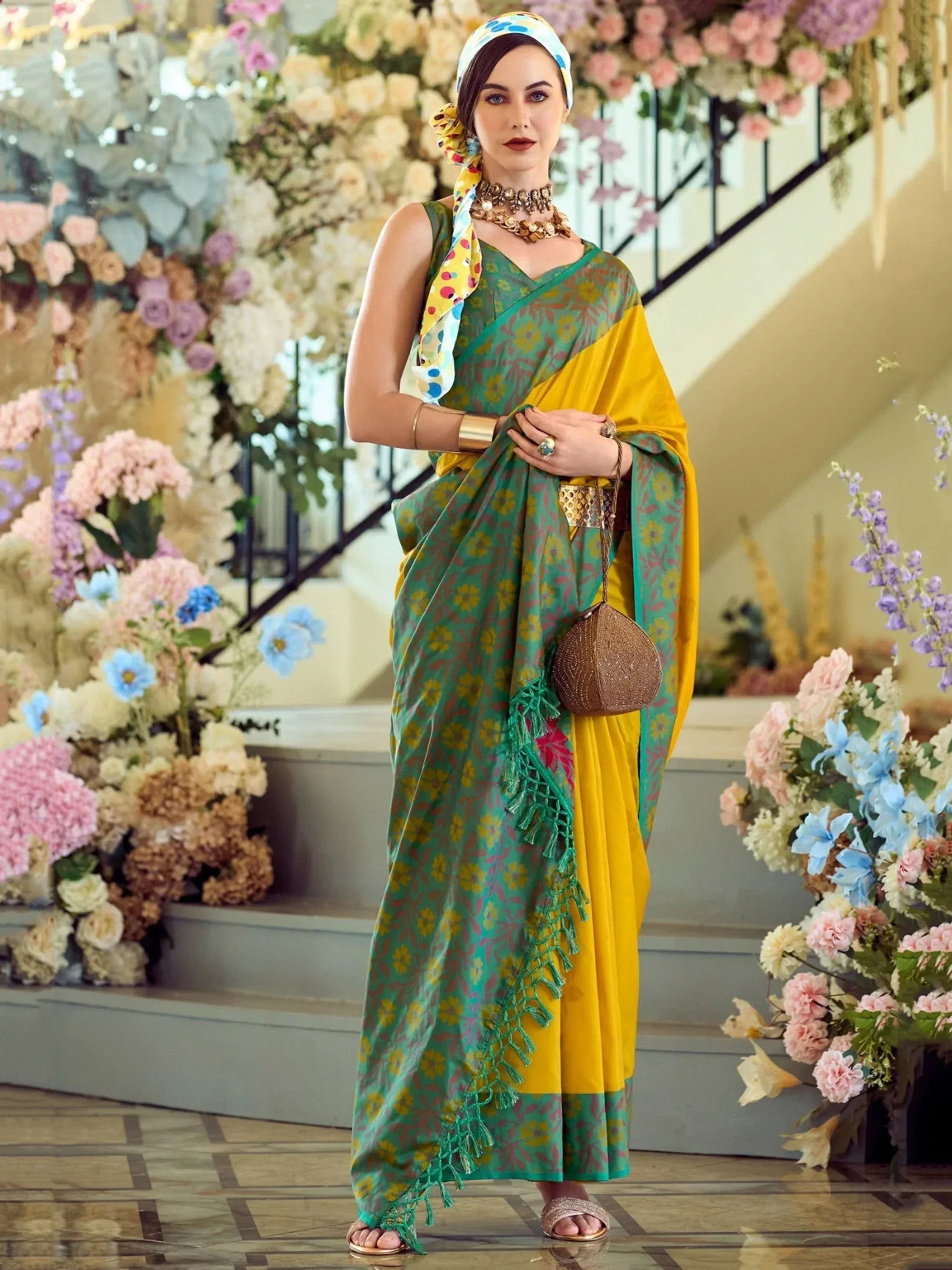 Woman in green and yellow floral saree with tassels, styled with headscarf and gold jewelry for ethnic occasions