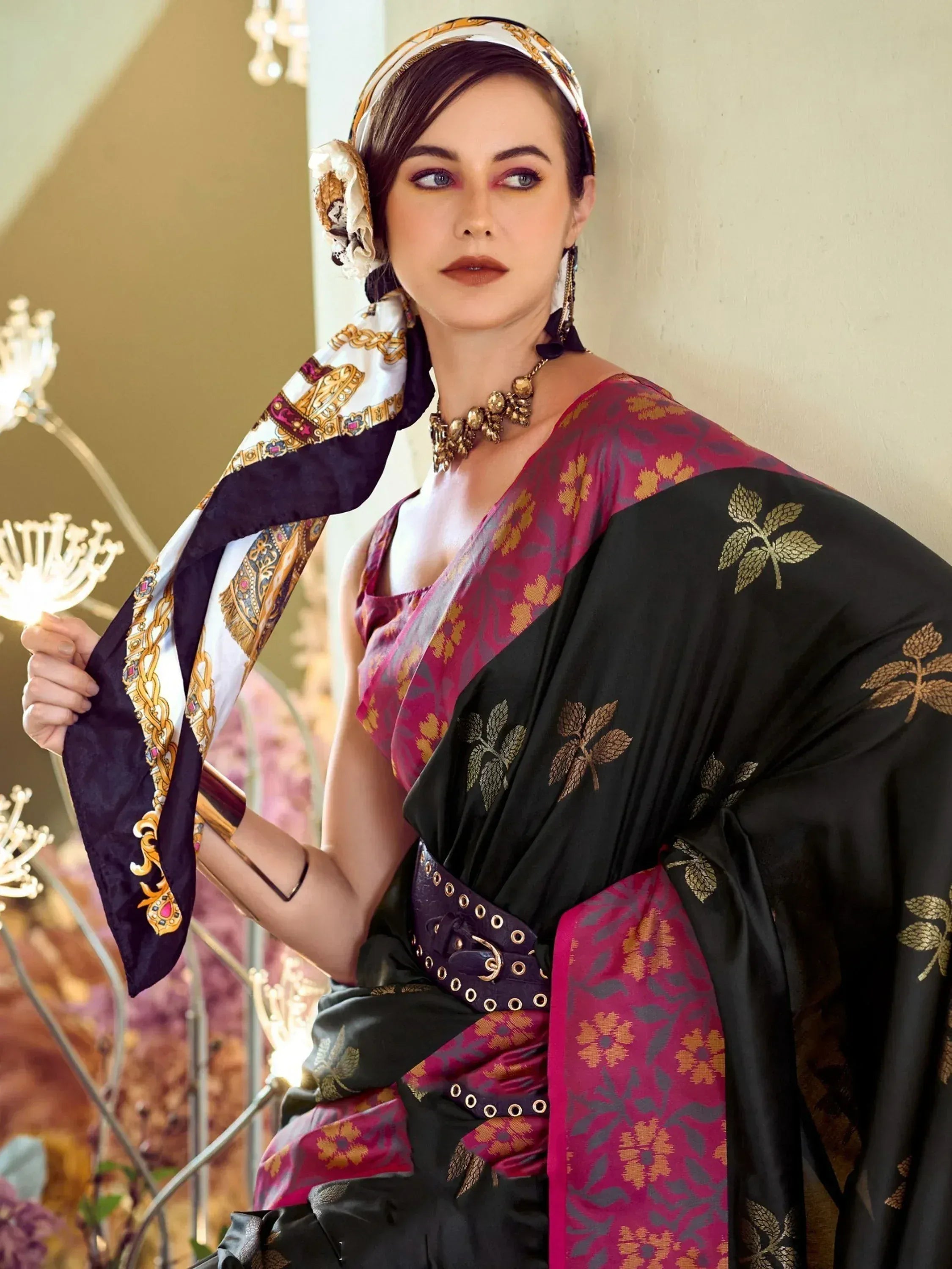Woman in black and maroon saree with gold leaf print, styled with patterned scarf and statement jewelry